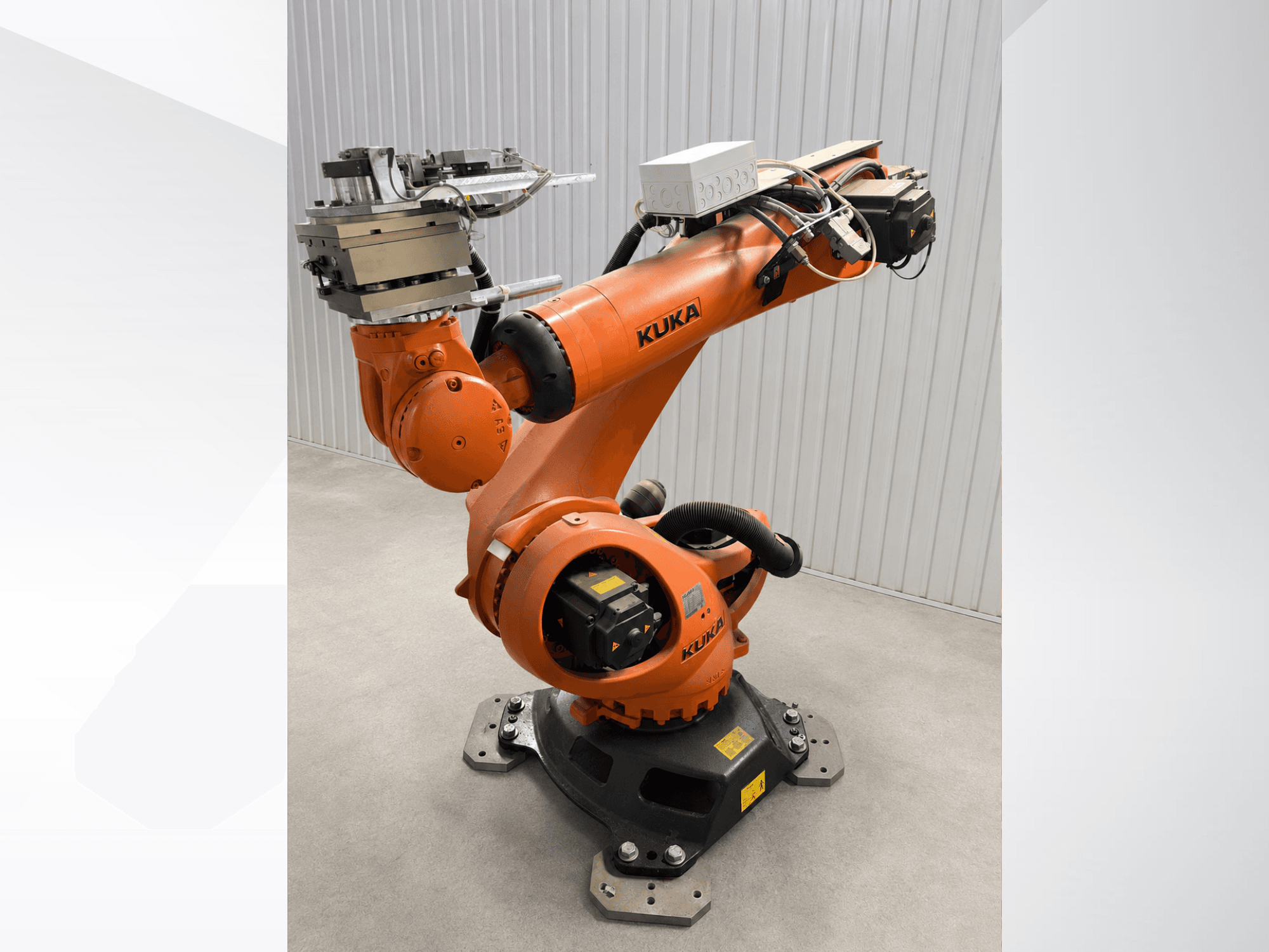 Braço robótico adicional KUKA KR 90 R3100 na cor laranja, vista lateral, mostrando as articulações, o controlador e o acessório de ferramentas no efetor final.