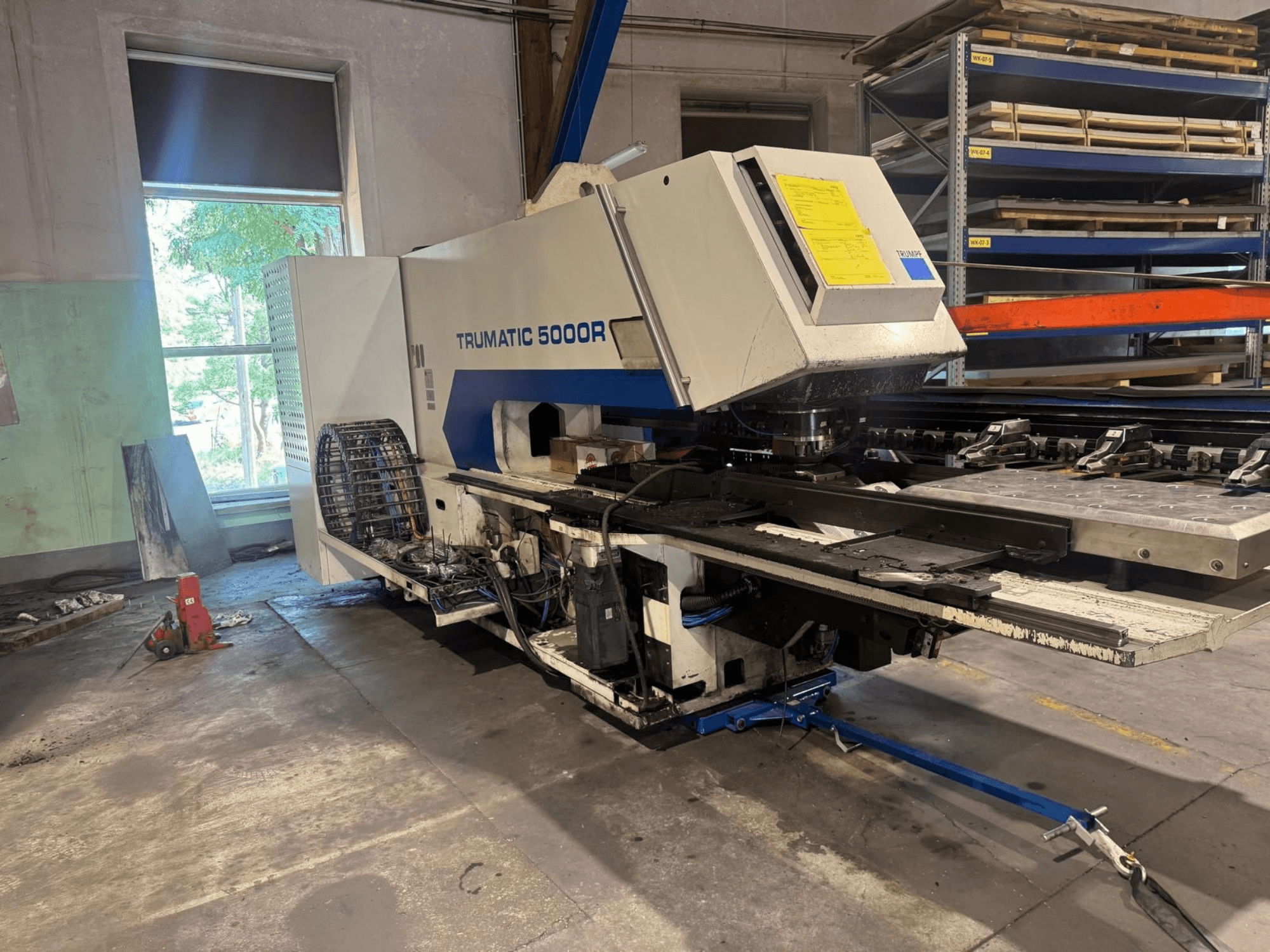Máquina de perfuração CNC TRUMPF TRUMATIC 5000R numa oficina, vista frontal que mostra os seus comandos e a área de perfuração.