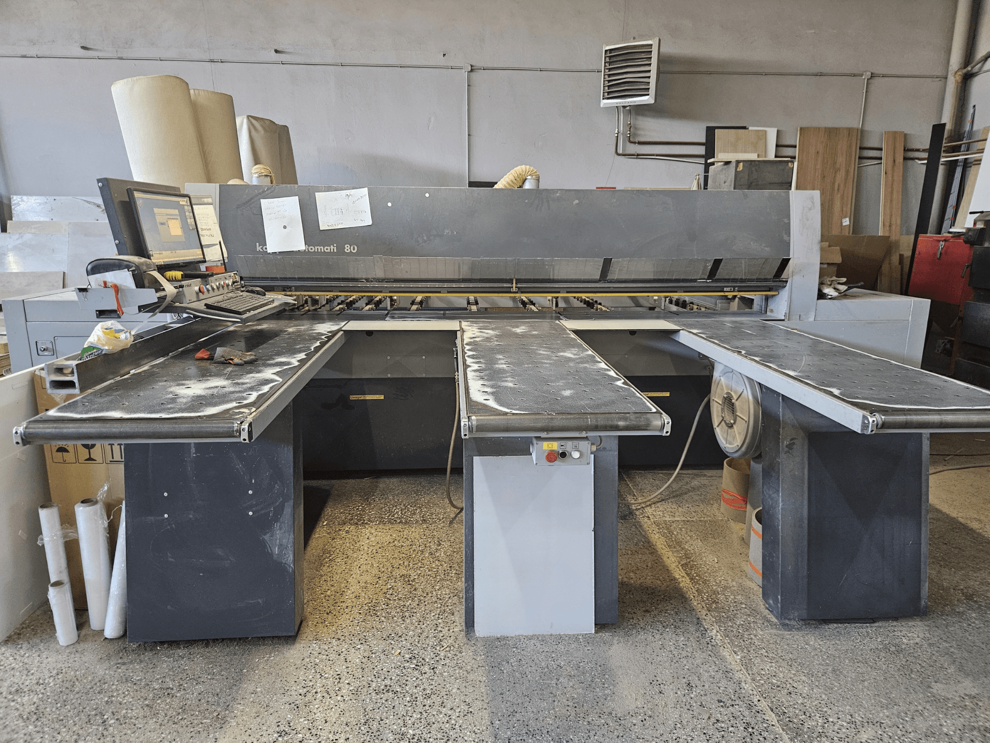 Máquina KAPPA Automati 80, vista frontal, com três mesas planas, painel de controlo e serradura dispersa nas superfícies.