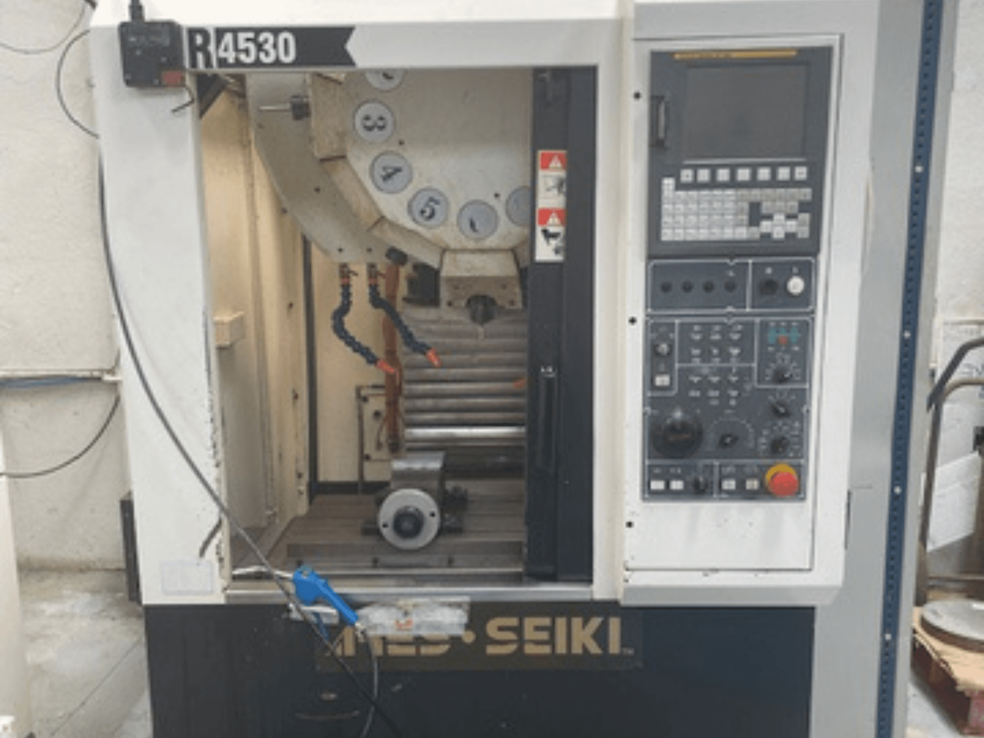 Centro de maquinação vertical ARES-SEIKI R4530, vista frontal mostrando o painel de controlo e a área de trabalho com fuso e sistema de refrigeração.