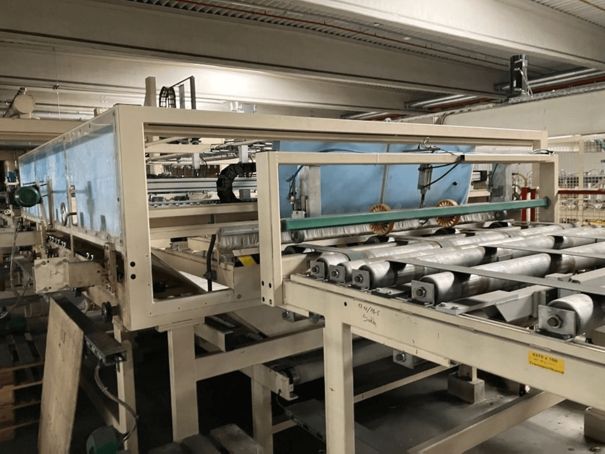 Prensa de laminação WEMHÖNER KT-F-1E, vista lateral, com rolos e comandos para o processamento de material em fábrica.