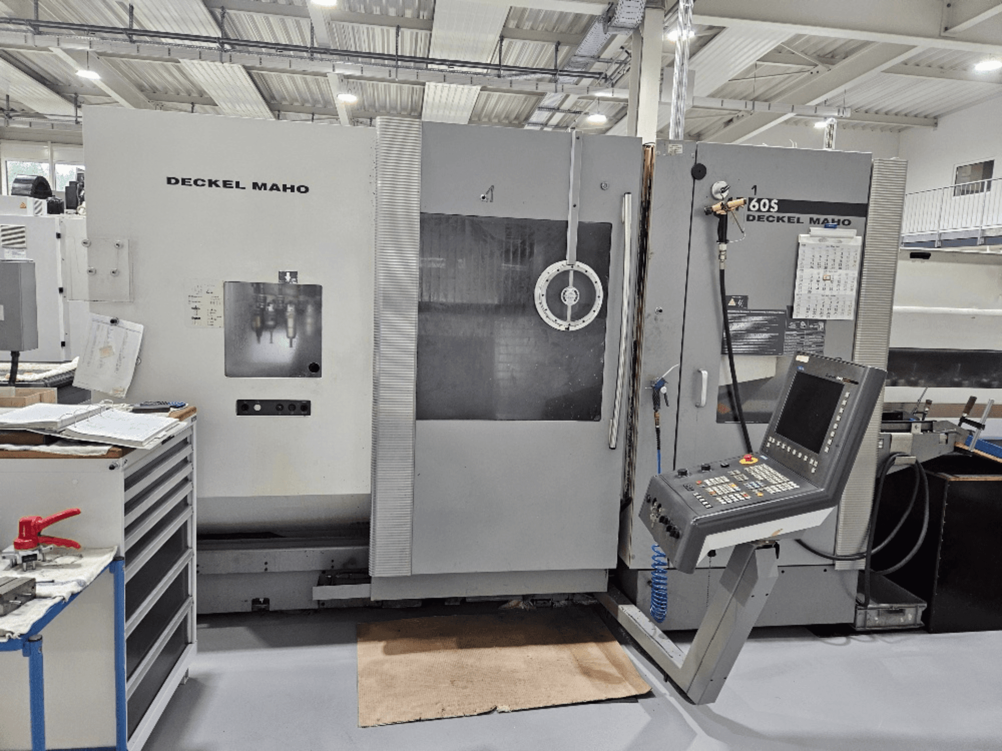 Máquina CNC Deckel Maho 605 com painel de controlo e caraterísticas operacionais, vista de frente numa oficina.
