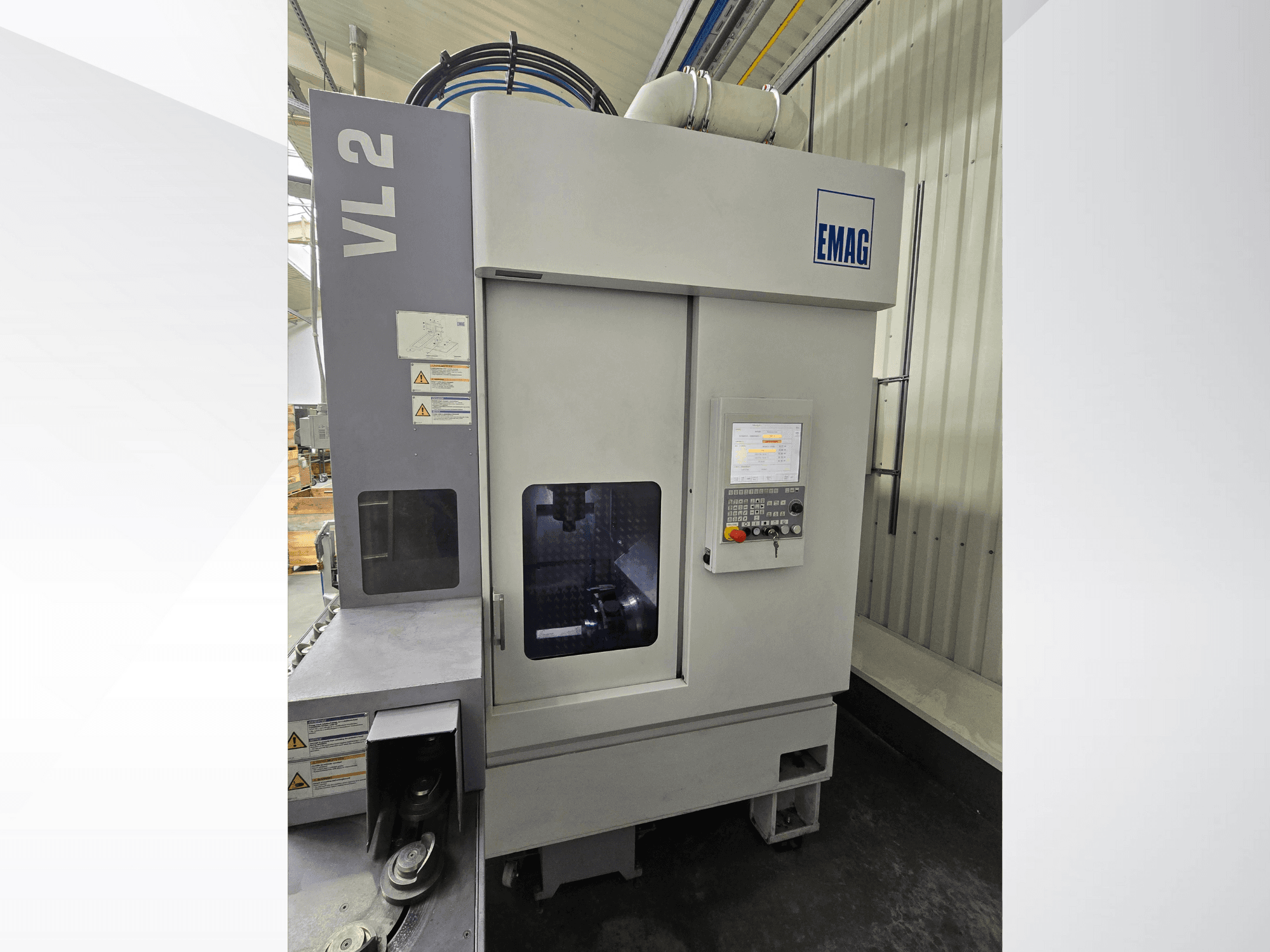 Máquina de precisão EMAG VL 2 em vista frontal, com painel de controlo digital e janela de visualização para controlo da operação.