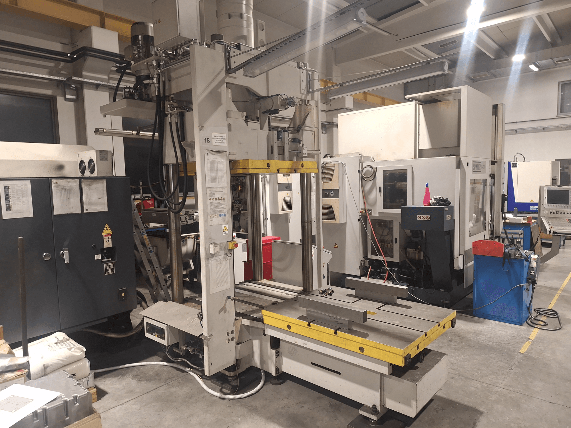 Fresadora horizontal da Synergic, vista frontal; possui uma mesa ampla e vários painéis de controlo, numa oficina.