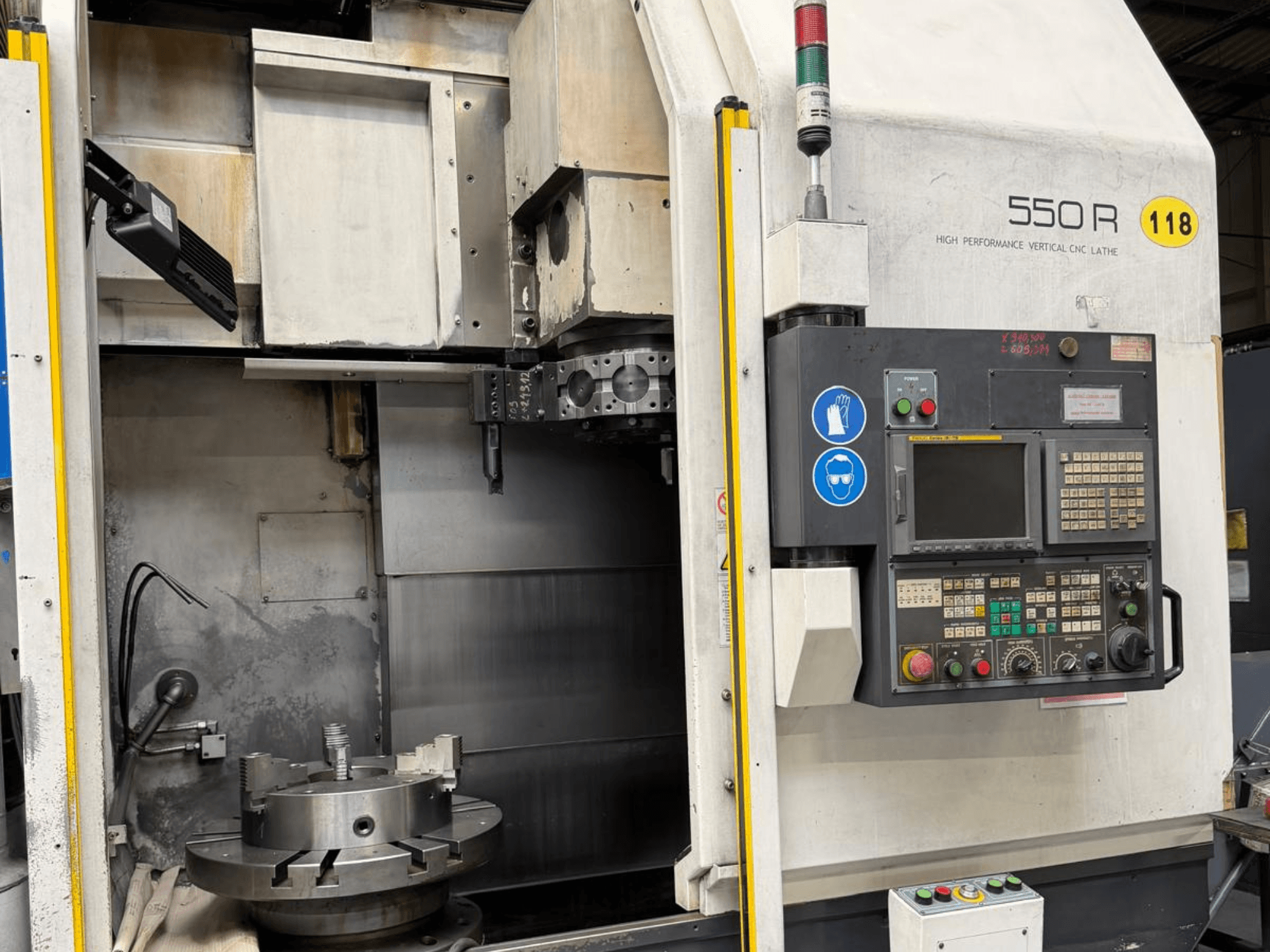 Torno CNC vertical de alto desempenho 550 R, vista frontal, mostrando o painel de controlo, o mandril rotativo e os componentes operacionais.