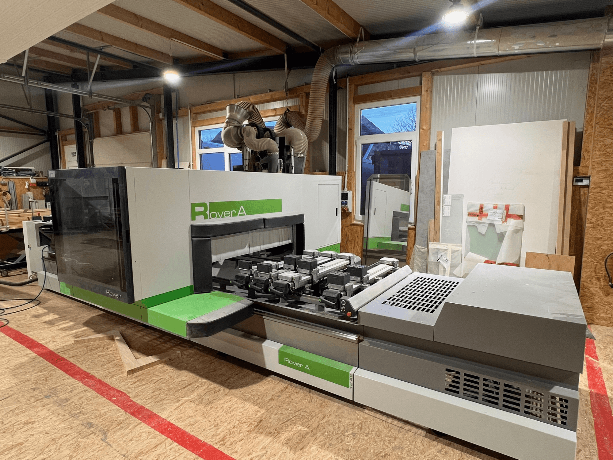 Centro de maquinação CNC para madeira BIESSE Rover A 1242, vista frontal mostrando o painel de controlo e a área de corte numa oficina.