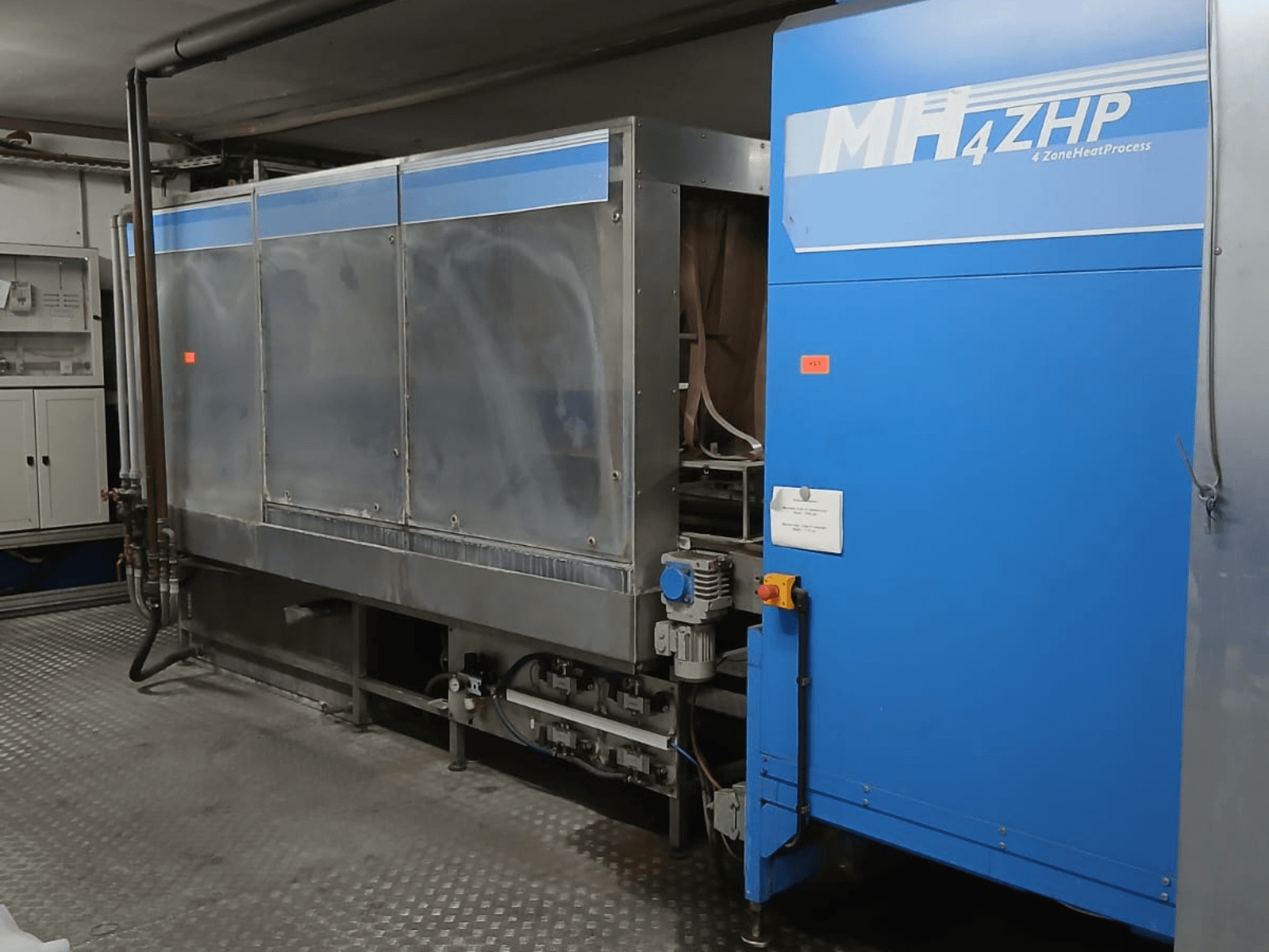 Máquina industrial MH 4ZHP em vista lateral, mostrando a estrutura em aço inoxidável e o painel azul com elementos de controlo.