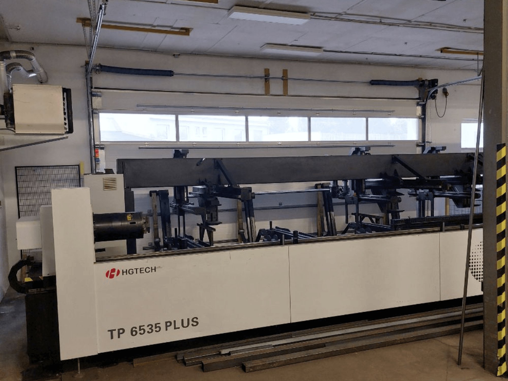 HGTECH TP 6535 PLUS, vista frontal de uma grande máquina industrial com vários braços para fabrico de precisão, colocada numa oficina.