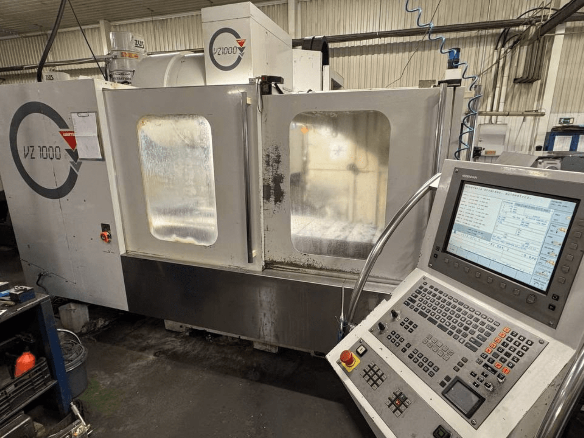 Vista frontal do centro de maquinação vertical WEMAS VZ 1000, com painel de controlo e portas de acesso transparentes.