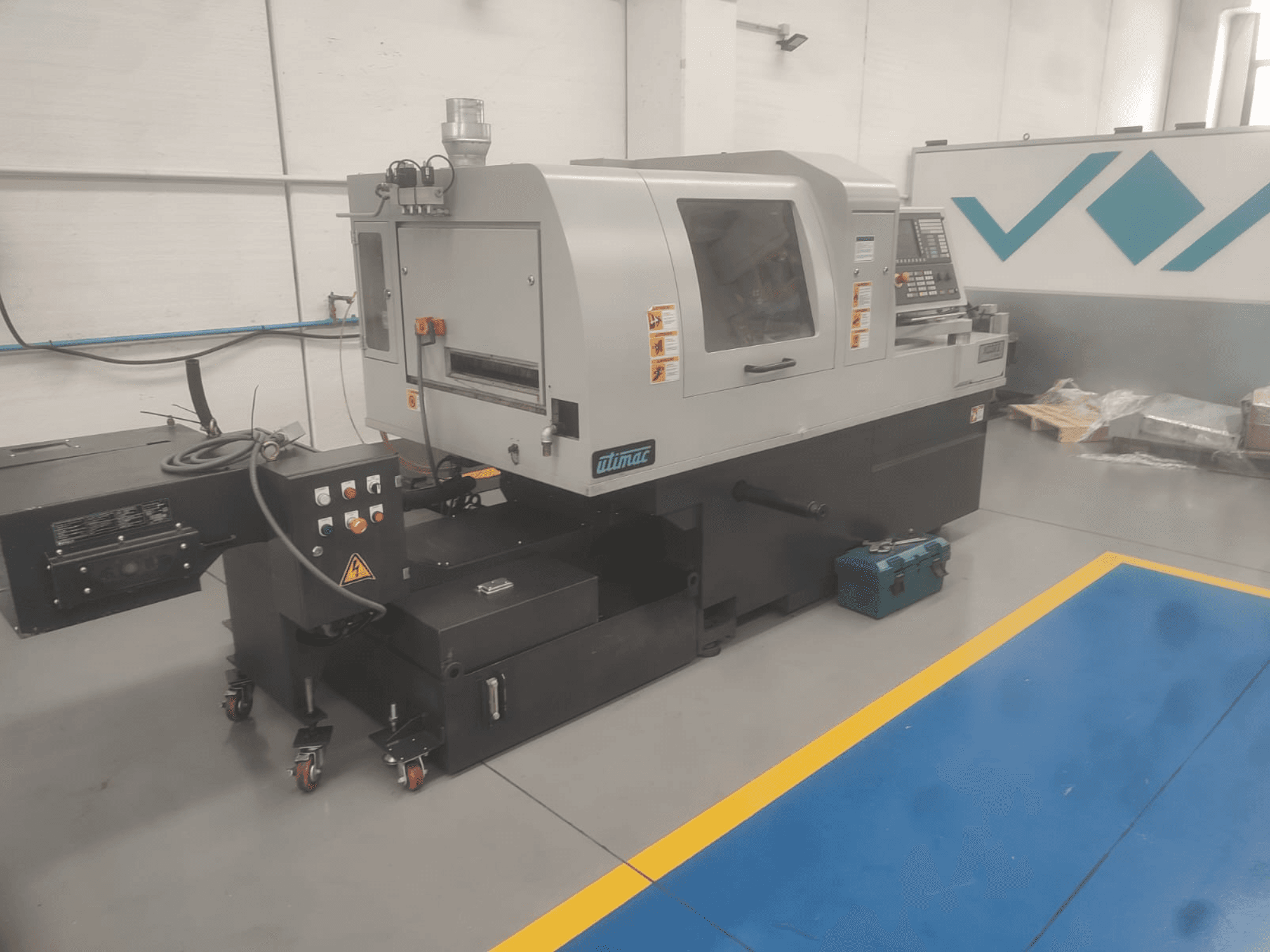 UTIMAC ISOLA XD 38 II Virador de tipo suíço, vista frontal, com painel de controlo e base com rodas para mobilidade.
