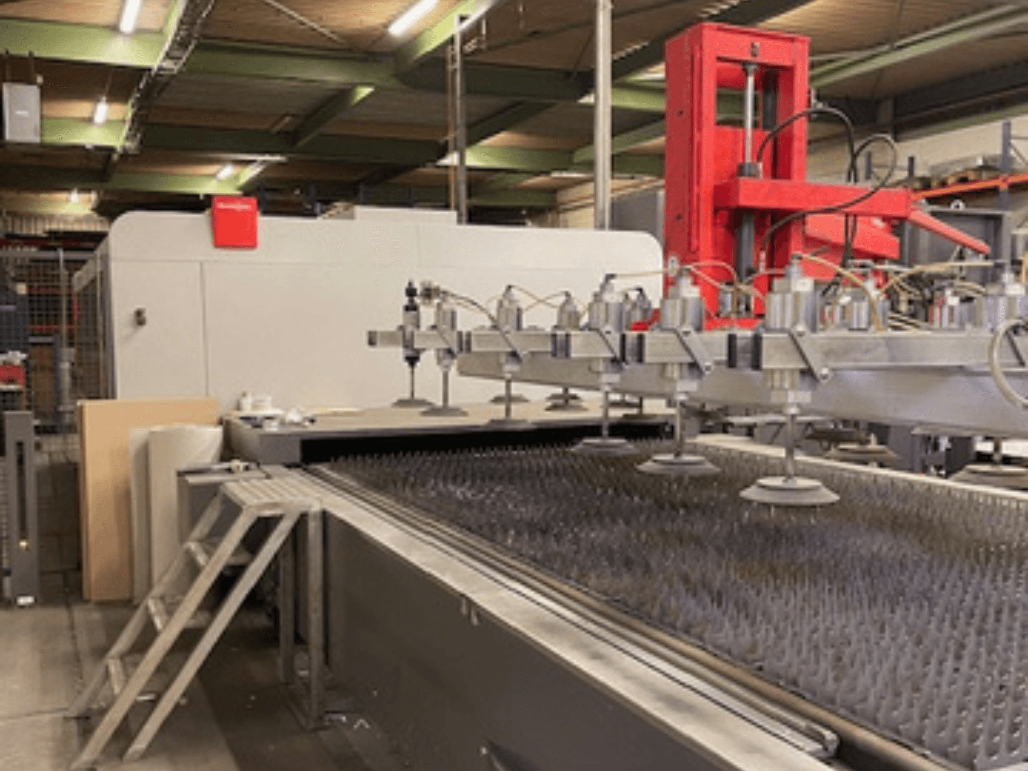 Bystronic BySprint Fiber 4020 Fiber 4Kw vista frontal de uma máquina de corte a laser de fibra com bicos e cama de corte.