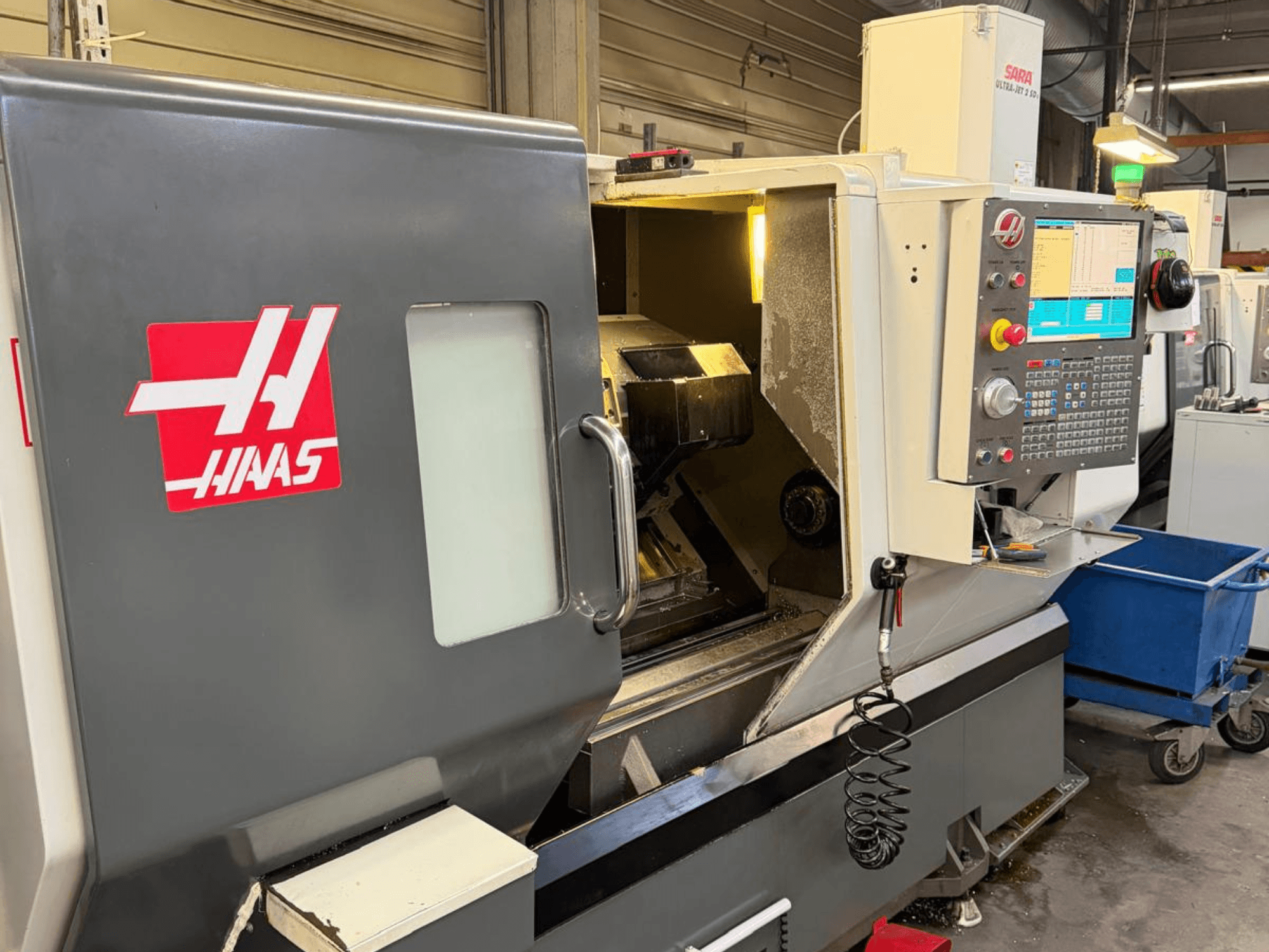Torneiro horizontal HAAS DS-30SSY, vista frontal, com painel de controlo e componentes internos visíveis, em ambiente de oficina.