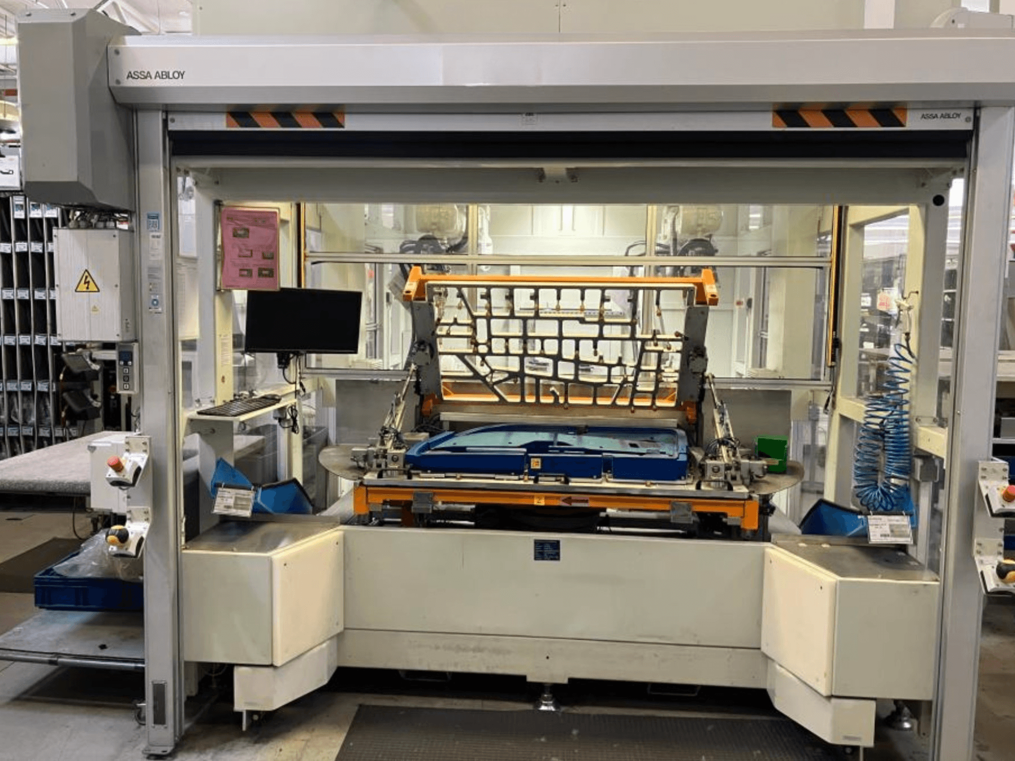 Máquina com braço robótico CHANGO AUDI TSV D5 TÜR numa fábrica, vista frontal que mostra o painel de controlo e a área de trabalho.