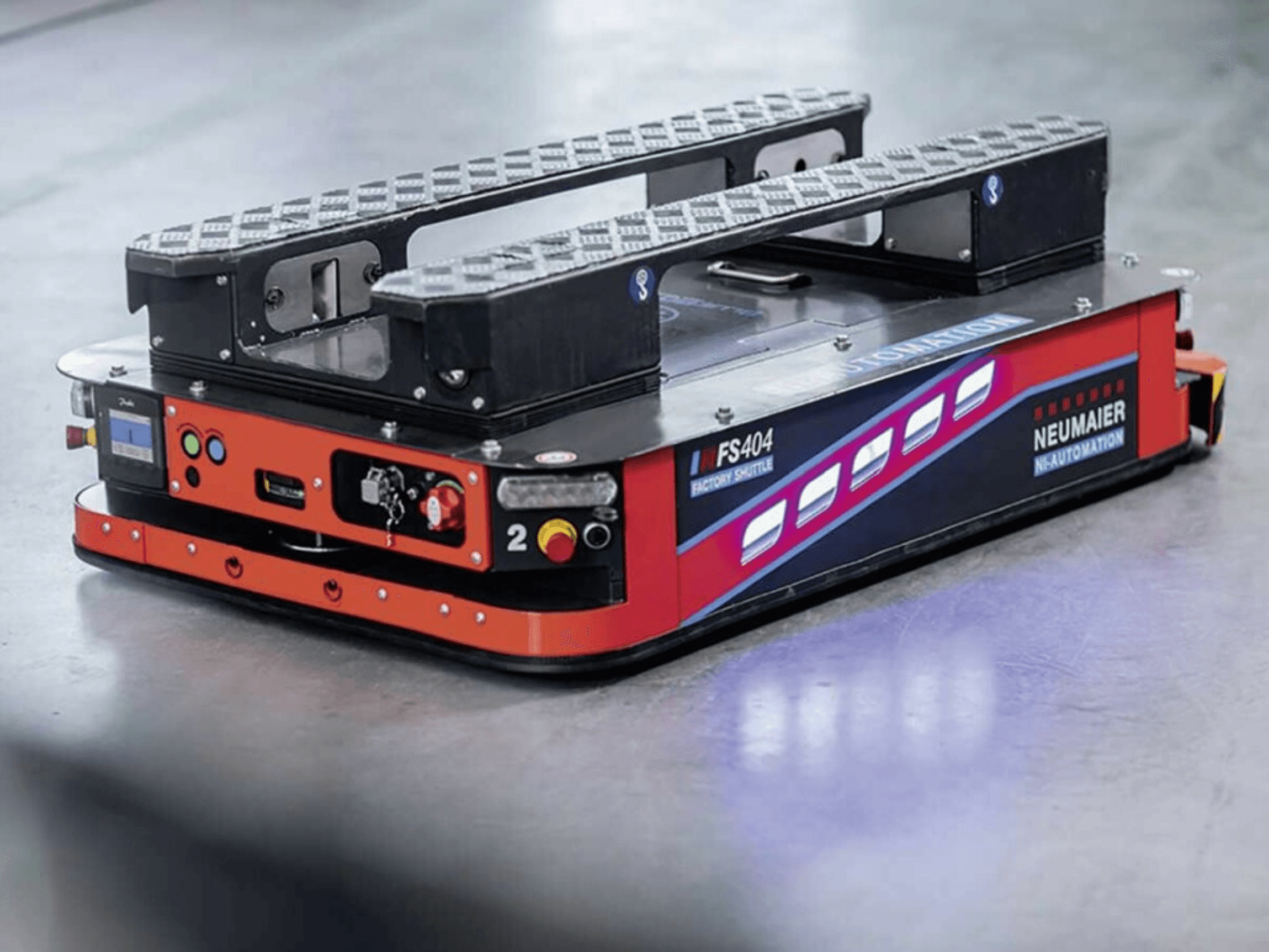 NEUMAIER AGV Factory Shuttle FS404, sistema de manuseamento de paletes de baixo perfil, vista lateral mostrando rodas, controlos e caraterísticas de segurança.