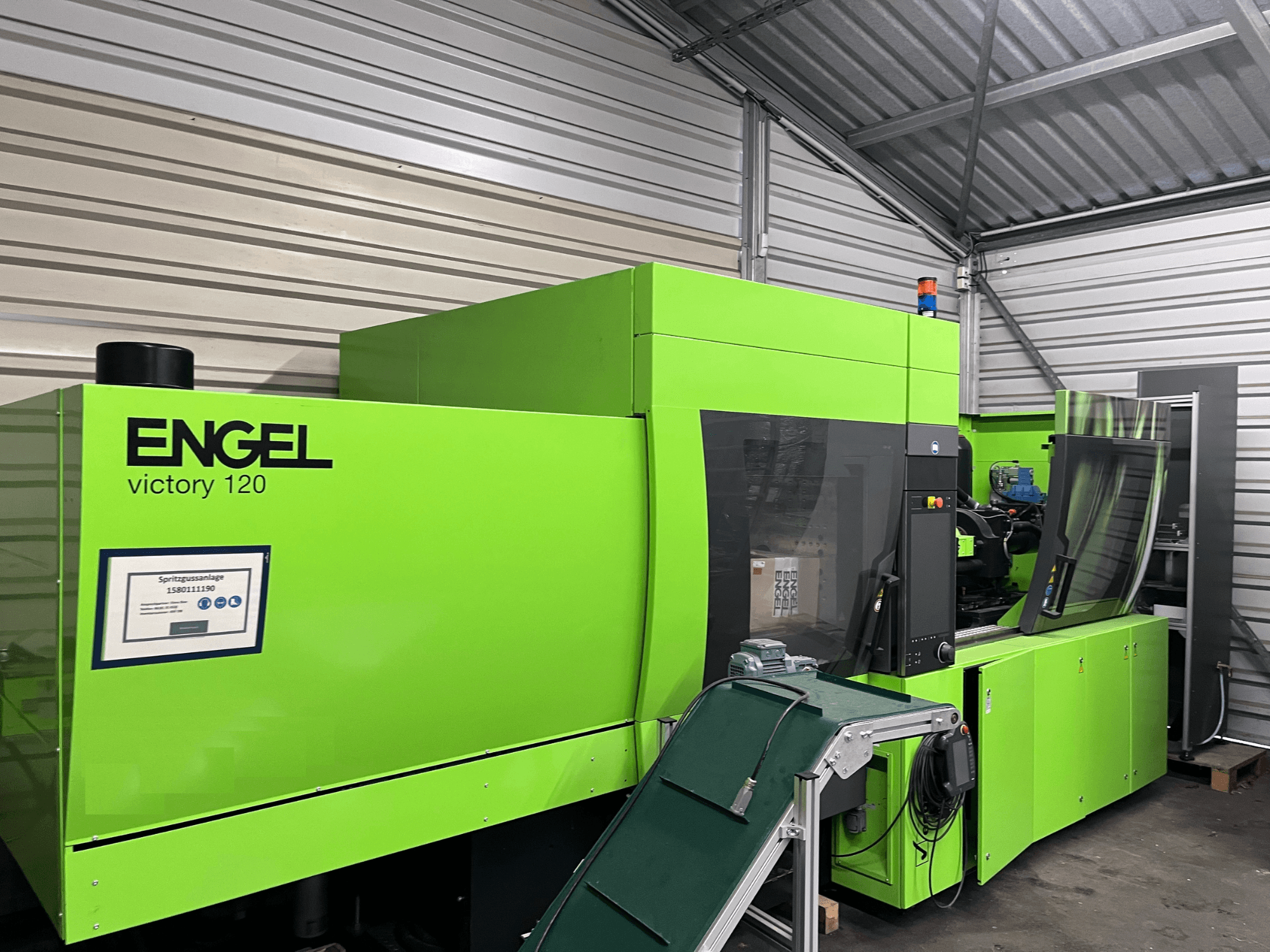 Máquina de moldagem por injeção hidráulica Engel Victory 120 BMG verde, vista frontal mostrando o painel de controlo e os componentes da máquina.