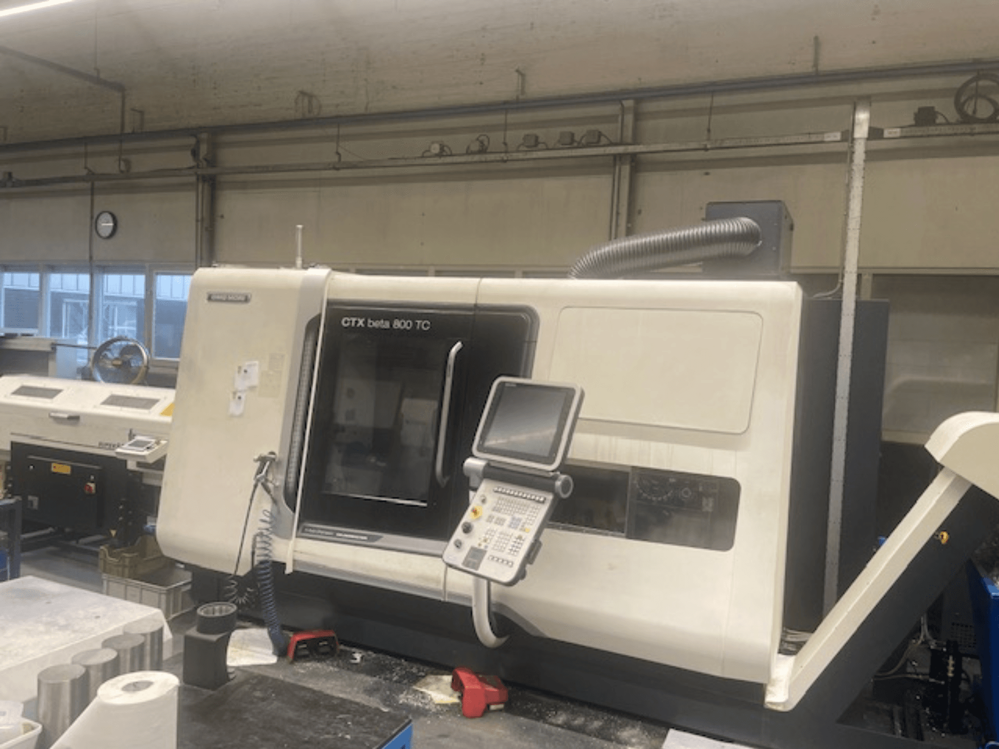 Máquina CTX beta 800 TC numa oficina; vista frontal mostrando o painel de controlo e o sistema de extração de poeiras.