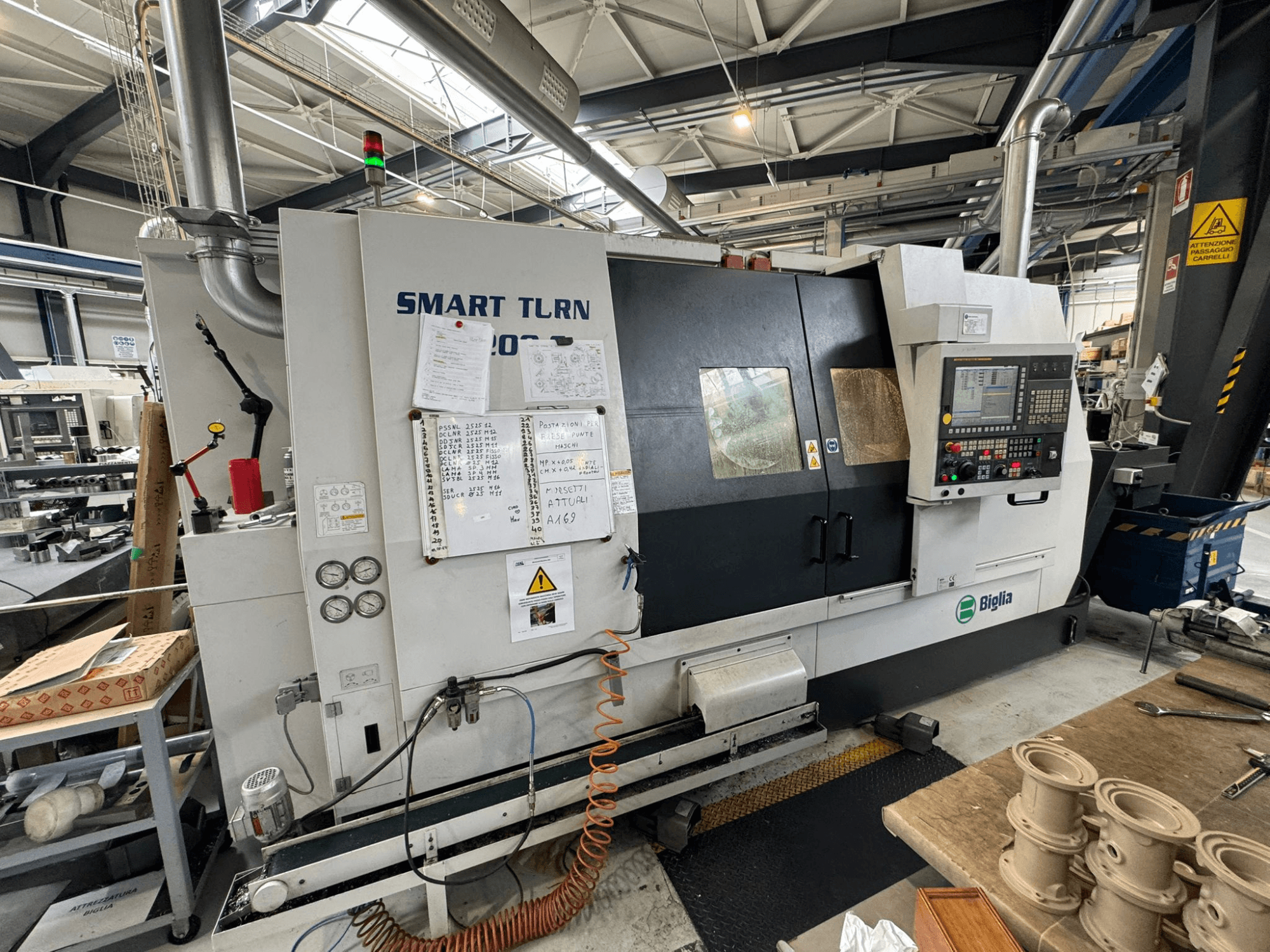 Centro de fresagem Biglia Smart Turn B1200S numa oficina, com painel de controlo, manómetros e indicadores de segurança.