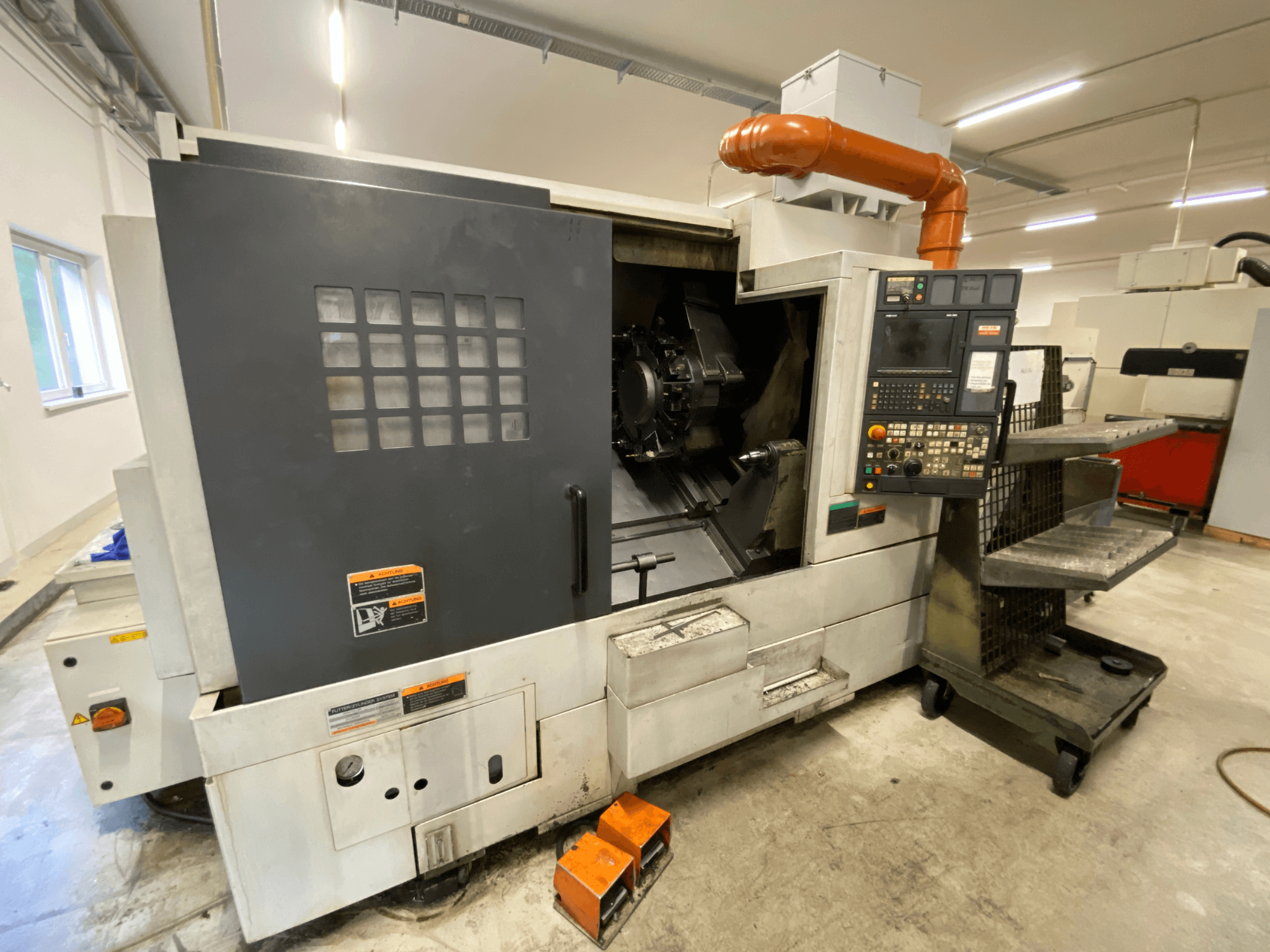 Centro de torneamento e fresagem DMG Mori Seiki NL2500Y/700, vista frontal que mostra o painel de controlo e os detalhes da estrutura da máquina.