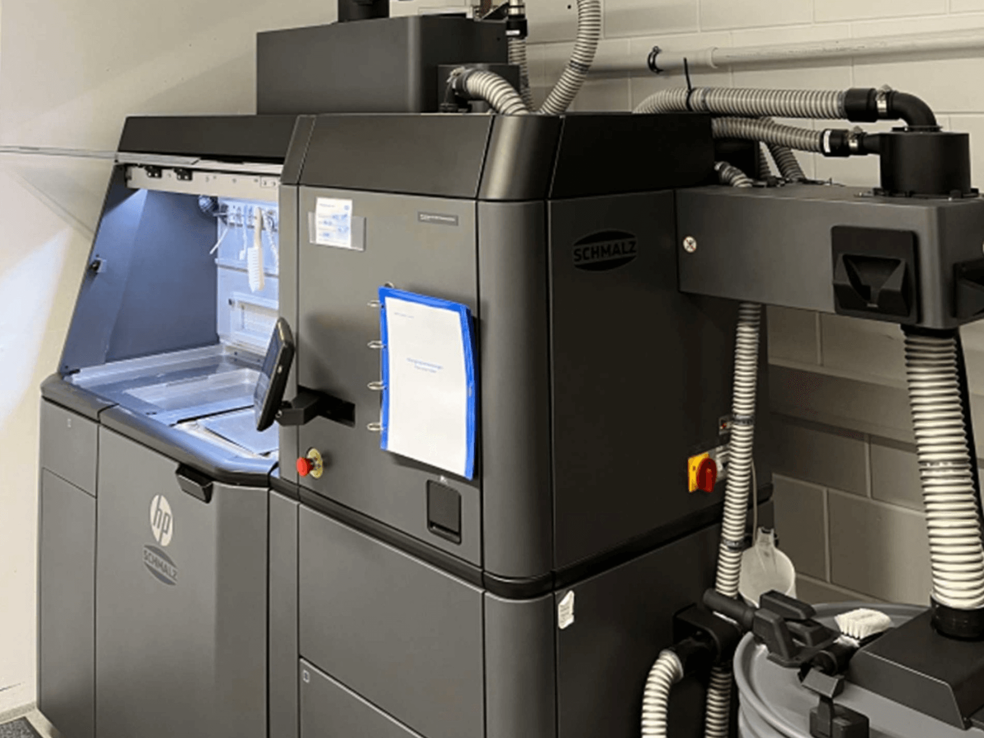 Impressora 3D de plástico HP Jet Fusion 3D 4200, vista lateral, mostrando o painel de controlo e os componentes internos.
