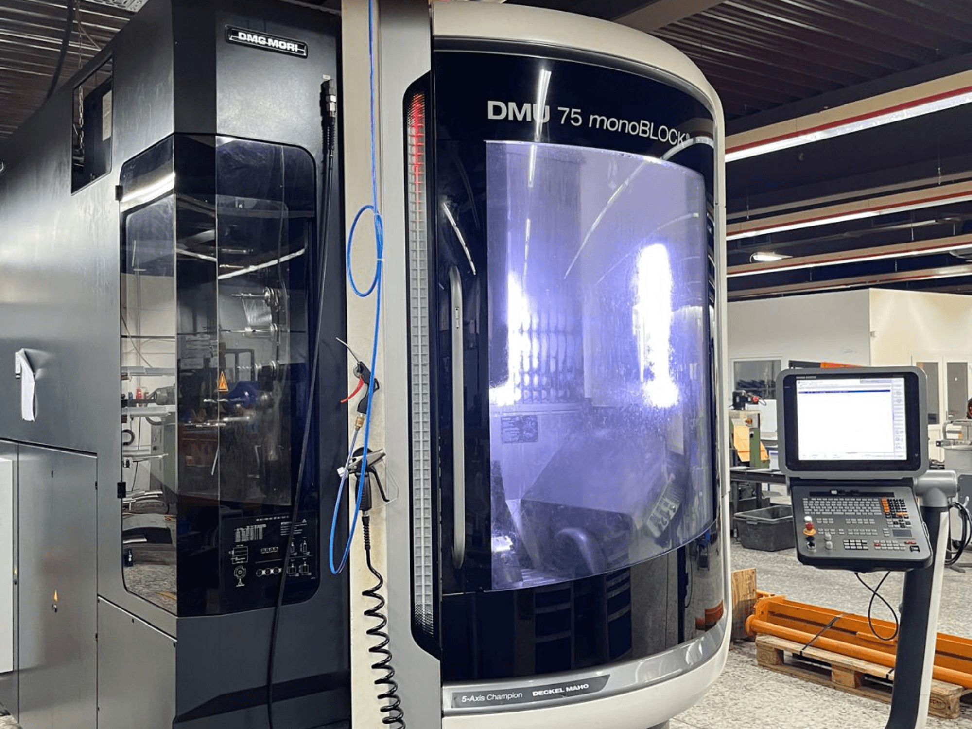 Centro de maquinação universal DMG MORI DMU 75 MonoBlock, vista frontal, mostrando o painel de controlo e a caixa distintiva.