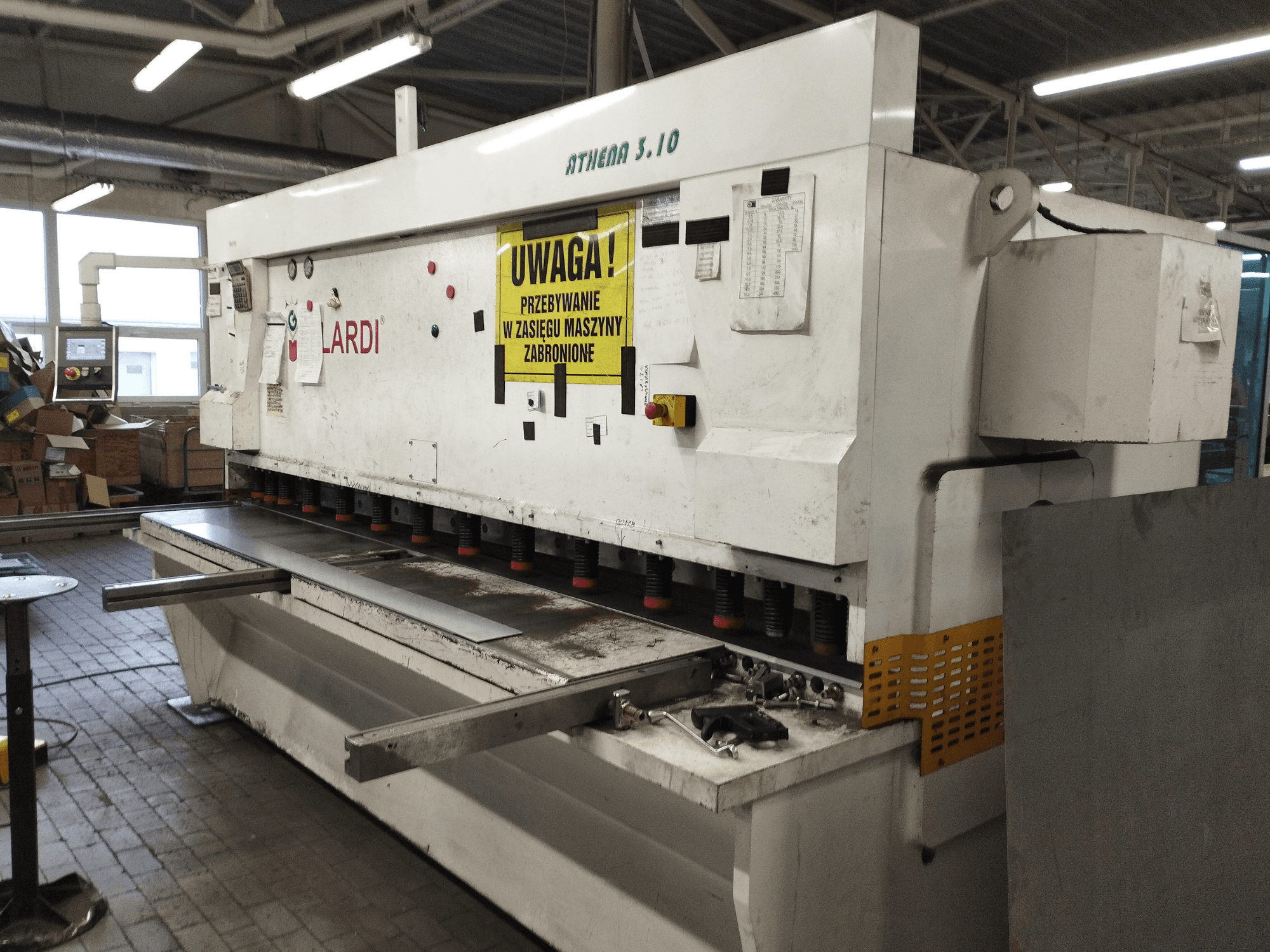 Máquina de corte CNC GILARDI ATHENA 3.10 numa oficina, vista frontal, mostrando o painel de controlo e as lâminas de corte.