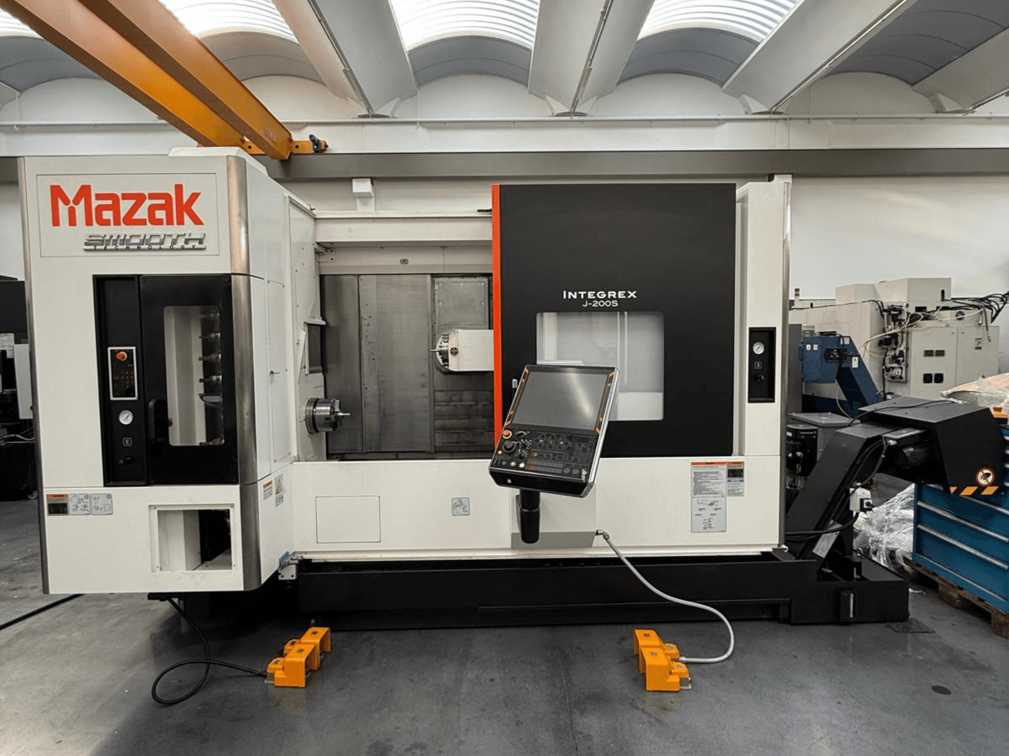 Centro de fresagem-torneamento Mazak INTEGREX J-200 S em vista frontal, com painel de controlo e área de maquinação, colocado no chão de fábrica.