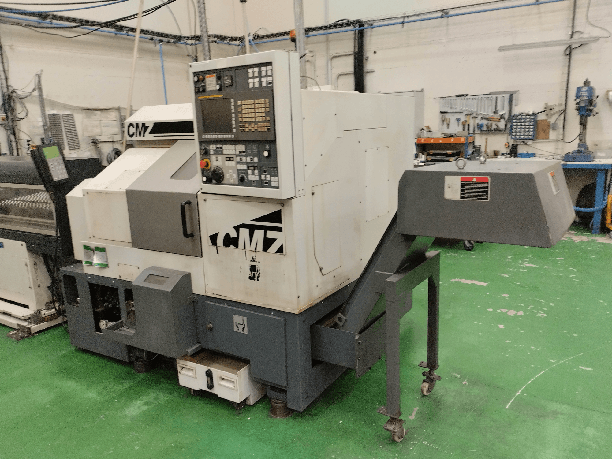 Centro de torneamento-fresagem CMZ TB-67M em vista frontal, com painel de controlo e mecanismo de alimentação, colocado num ambiente de oficina.
