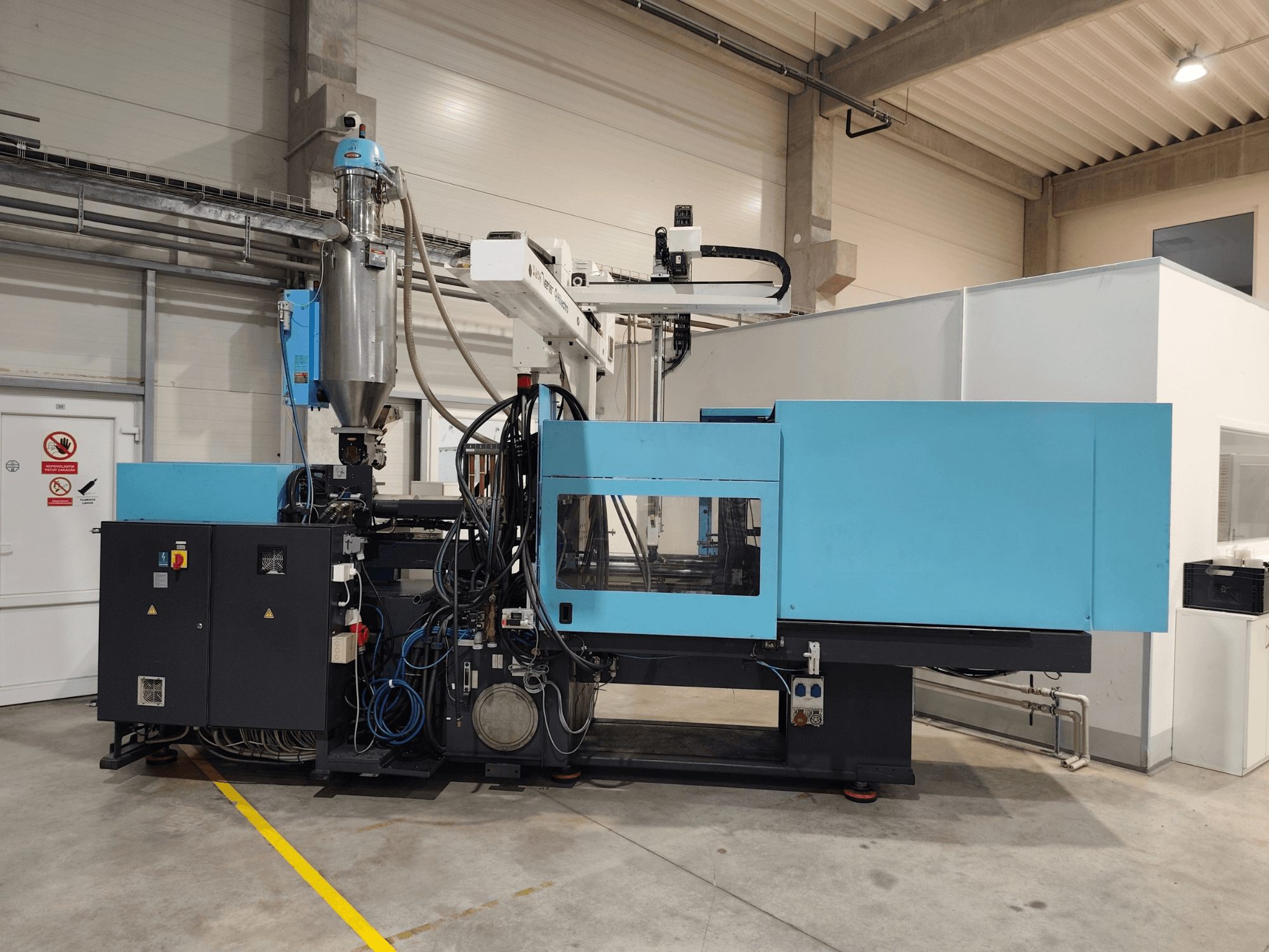 Vista frontal de uma máquina de moldagem por injeção hidráulica DEMAG Ergotech Extra 160-430, com o painel de controlo e a tremonha visíveis.