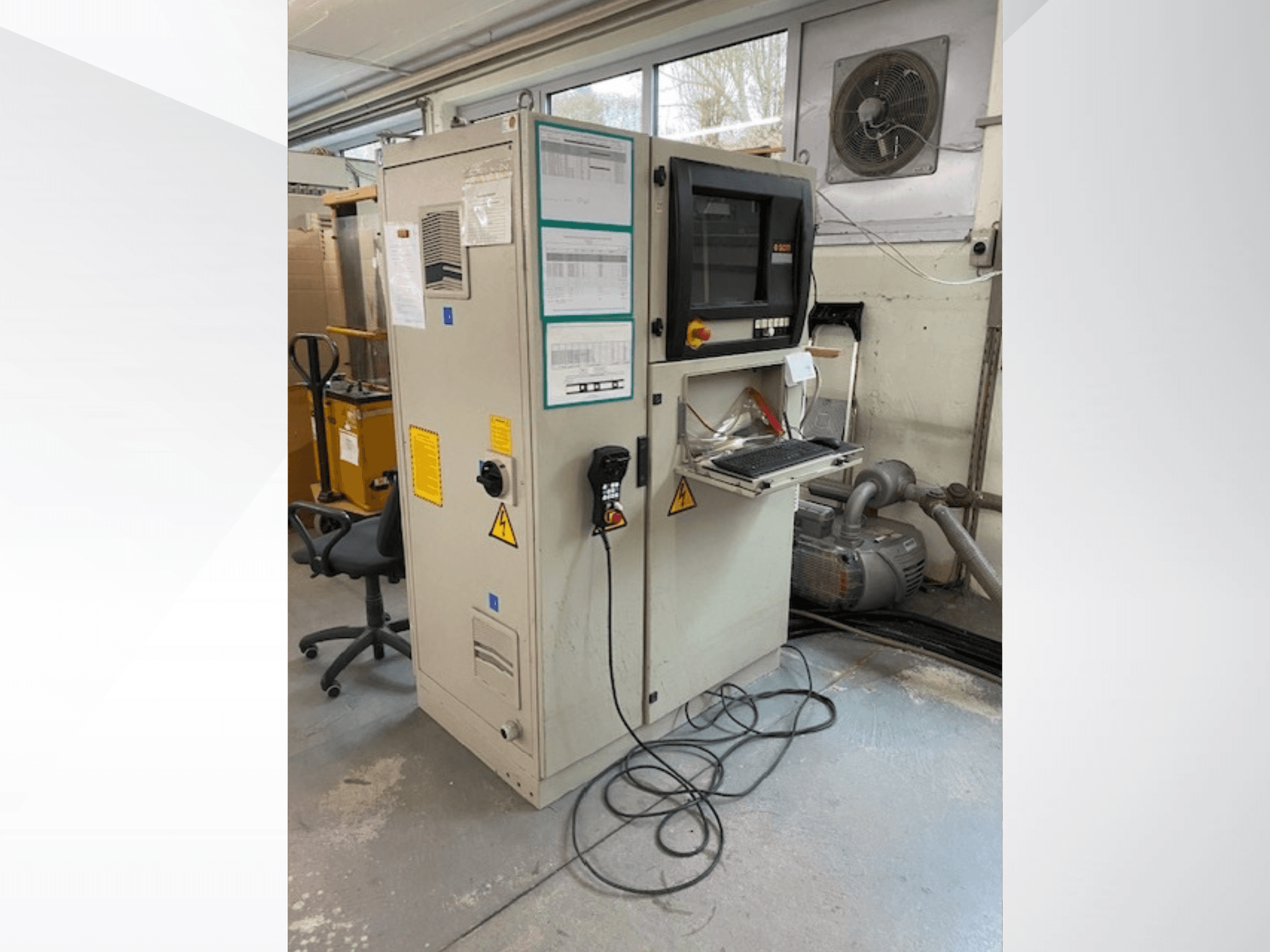 Centro de maquinação CNC para madeira SCM Record 240 em vista lateral, com painel de controlo, etiquetas de segurança e ligado a um motor.