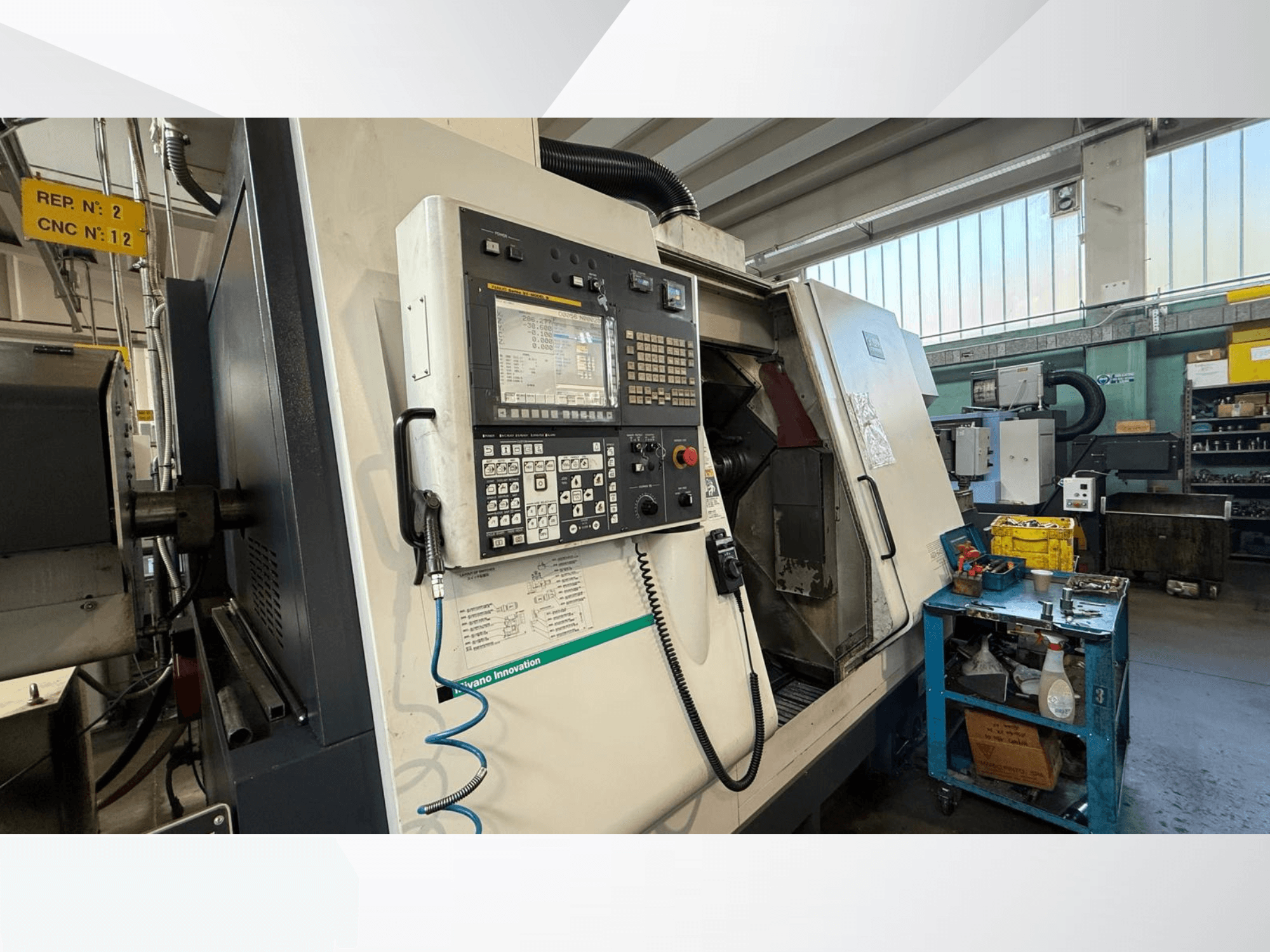 Vista frontal do torneiro horizontal Miyano ABX64 YY2, com painel de controlo, com ferramentas e equipamento em ambiente de oficina.