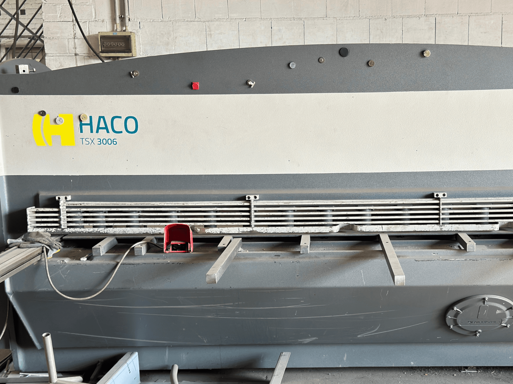Máquina de corte hidráulica HACO TSX3006 MOT, vista frontal, com lâminas de corte metálicas e painel de controlo, mostrando detalhes operacionais.