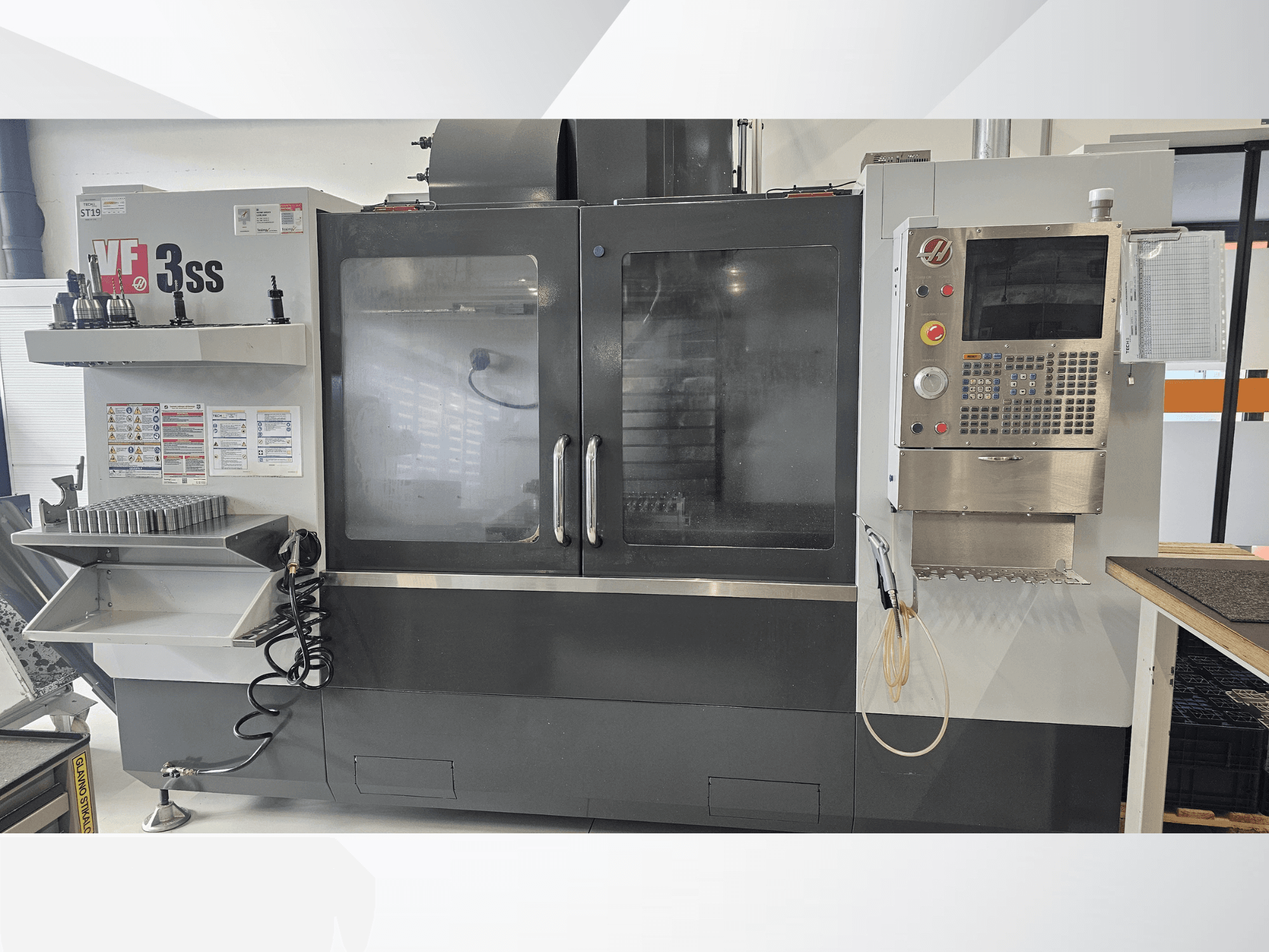 Centro de maquinação vertical HAAS VF-3SS, vista frontal, com painel de controlo, suporte de ferramentas e porta de vidro grande.
