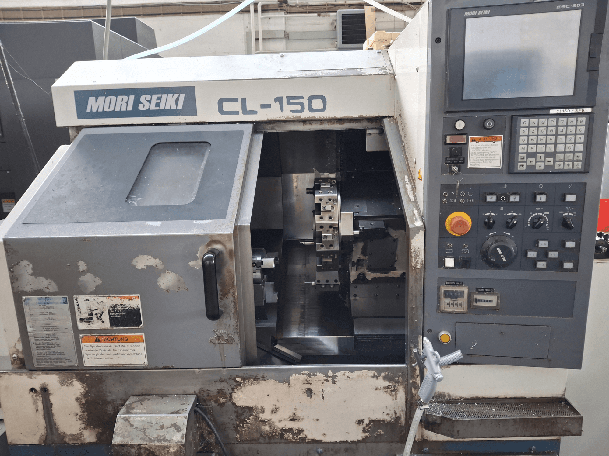 Torneiro horizontal MORI SEIKI CL-150, vista frontal. Painel de controlo, ferramentas de corte e ecrãs operacionais.