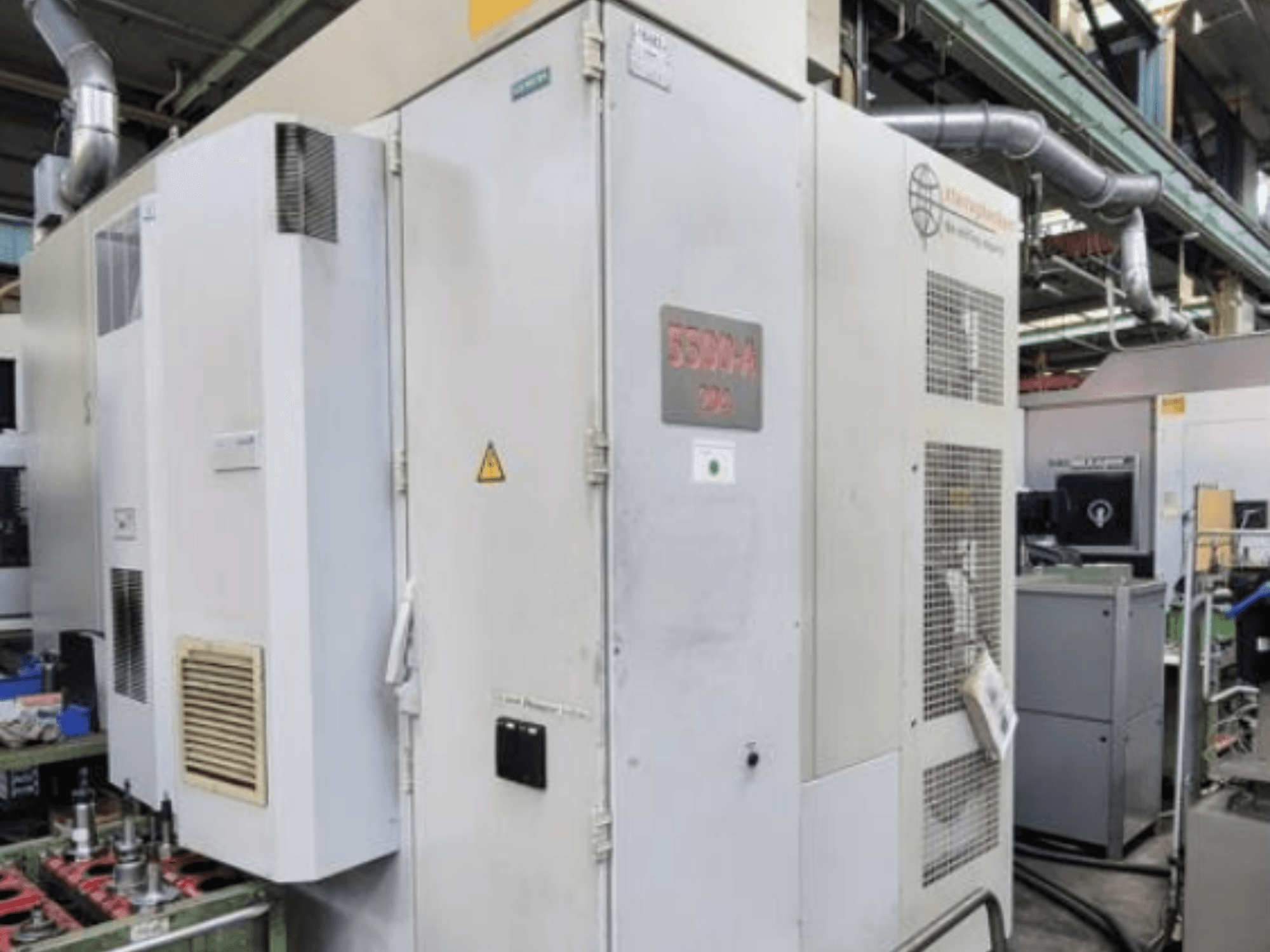 Centro de maquinação horizontal Starrag Heckert HEC 500 H/V, vista lateral mostrando o exterior com aberturas de ventilação e sinalização de aviso.