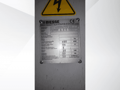 Placa de especificações técnicas do Centro de Maquinação Biesse NC, com detalhes de tensão, peso e potência, vista lateral.