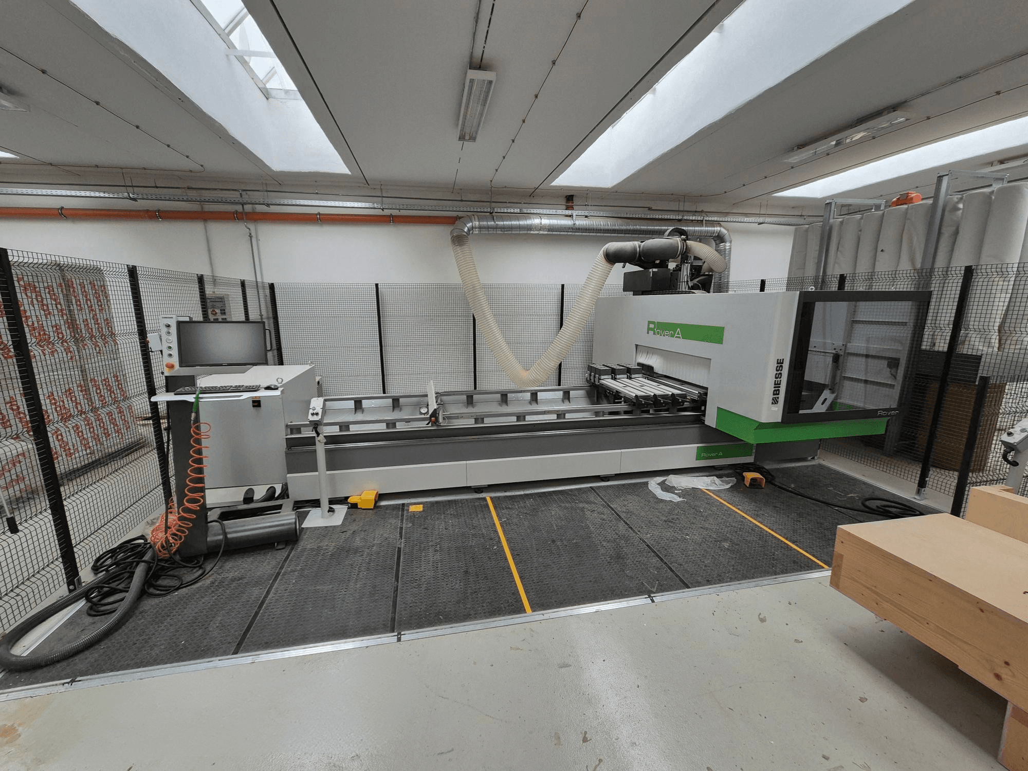 Biesse Rover Uma máquina CNC numa oficina, vista frontal. Inclui um painel de controlo, sistema de vácuo e superfície de trabalho.