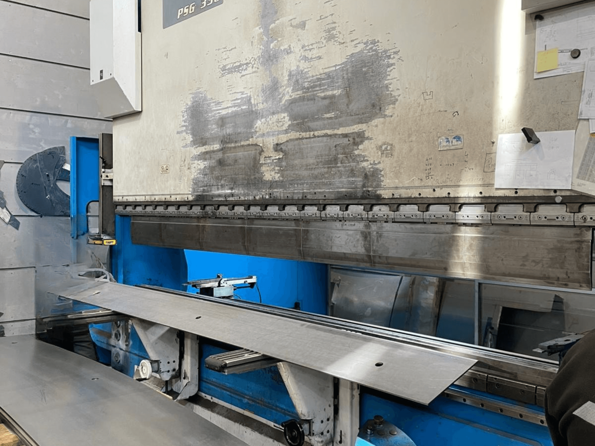 Prensa dobradeira GASPARINI PSG 330/4000 Variante C em oficina, mostrando a área de dobragem com chapa metálica e os controlos da máquina.