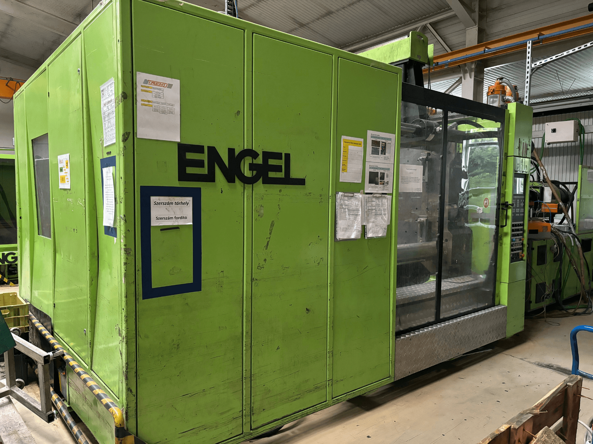 Máquina de moldagem por injeção hidráulica Engel DUO 5550/800, vista frontal, com exterior verde e painel de acesso transparente.