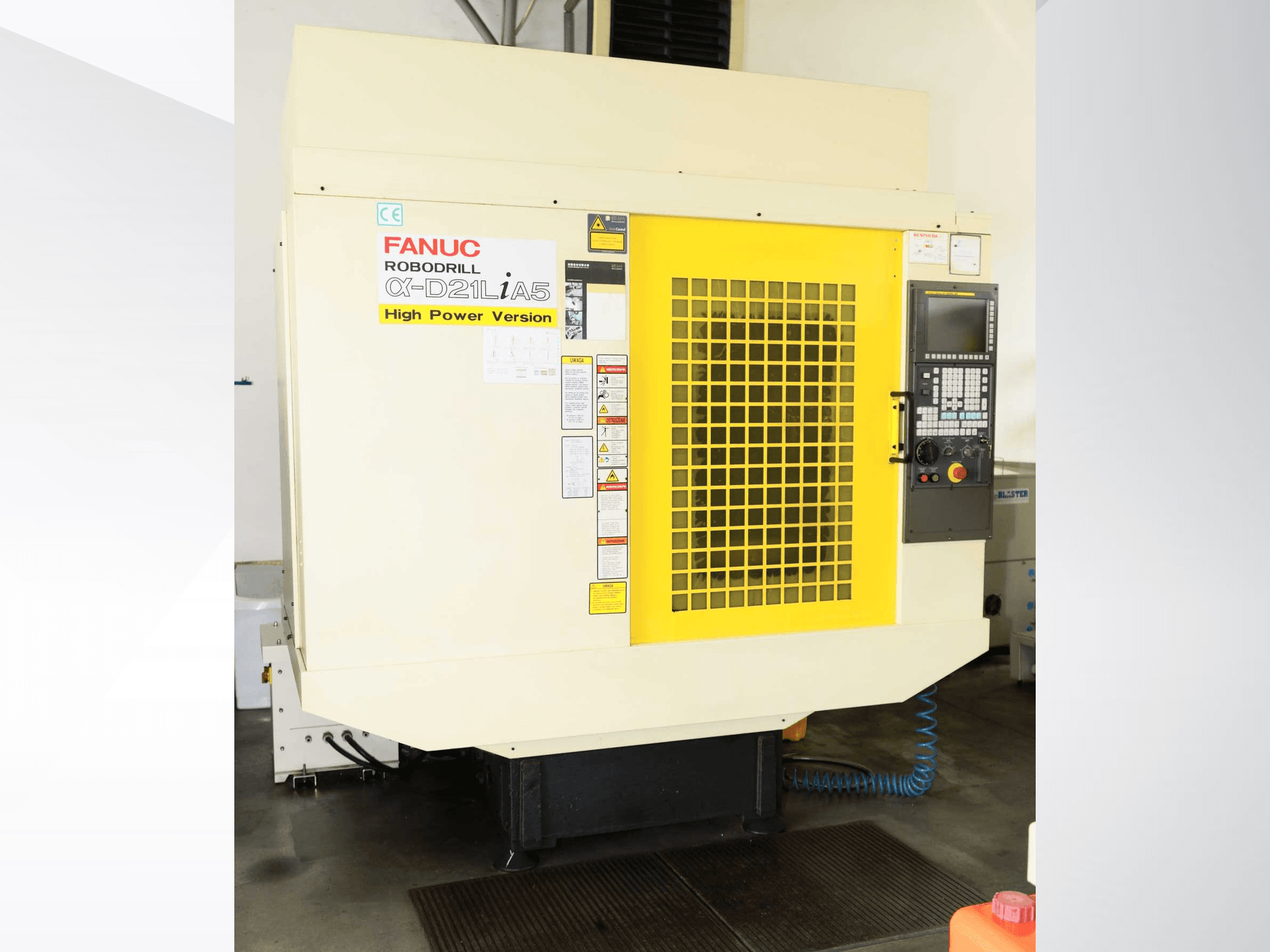 Centro de maquinagem vertical FANUC ROBODRILL α-D21LiA5, vista frontal com grelha de segurança amarela e detalhes do painel de controlo.