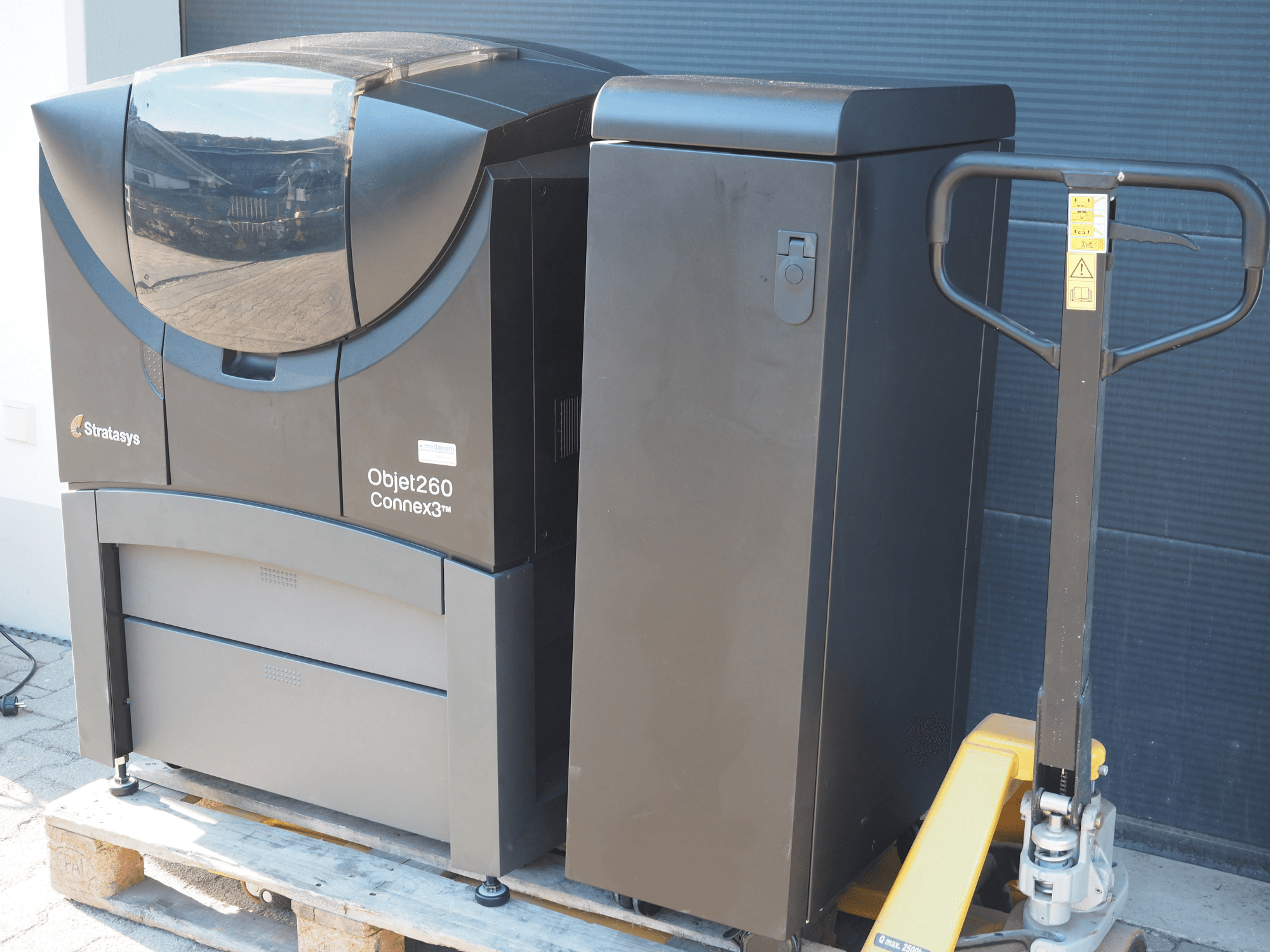 Impressora 3D de plástico Stratasys Objet260 Connex3, vista lateral, apresenta um design compacto com painel de controlo e depósito de material ligado.