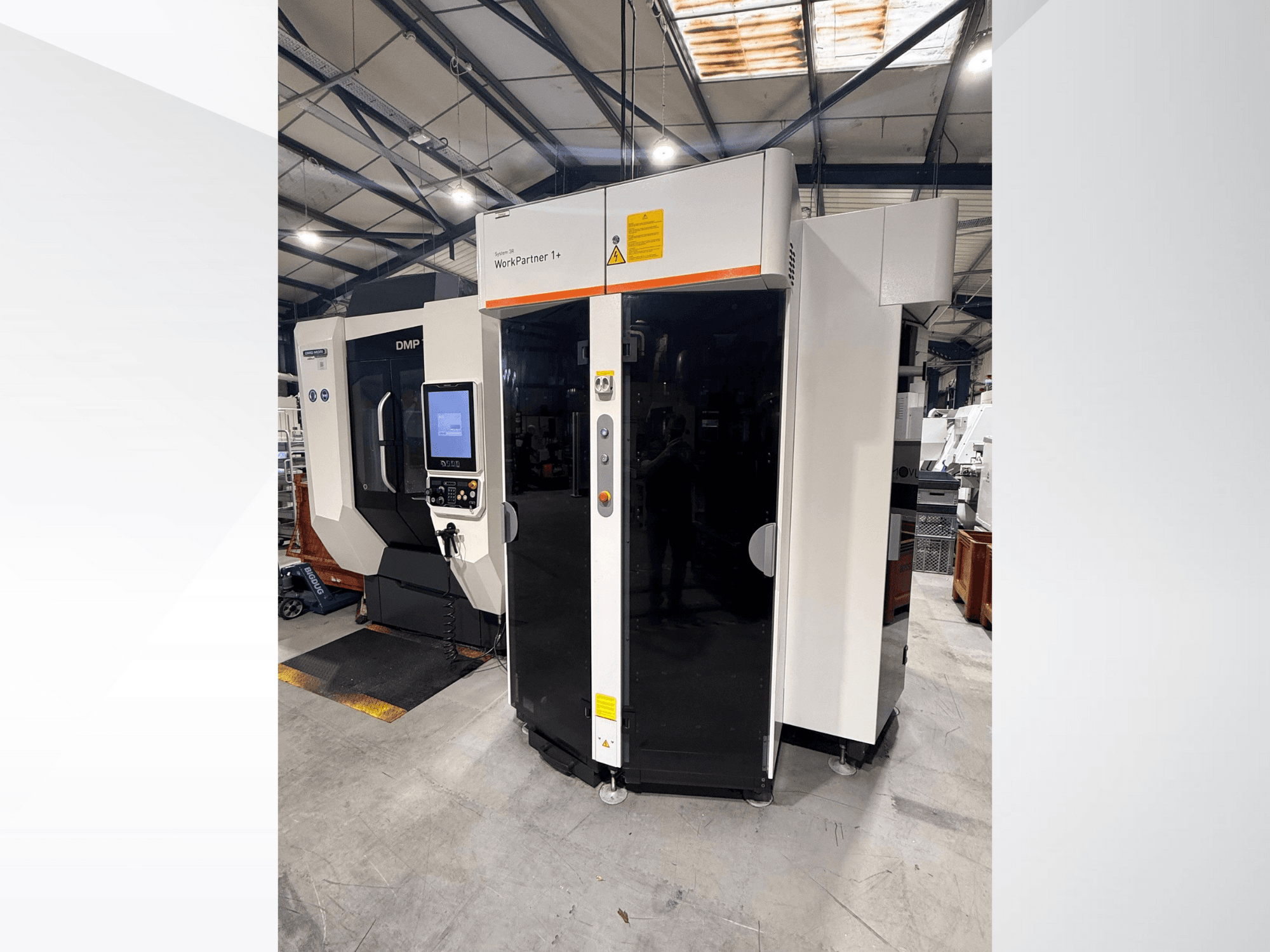 DMP WorkPartner 1+, vista frontal; possui um painel de ecrã tátil e indicadores de segurança num ambiente de fabrico.