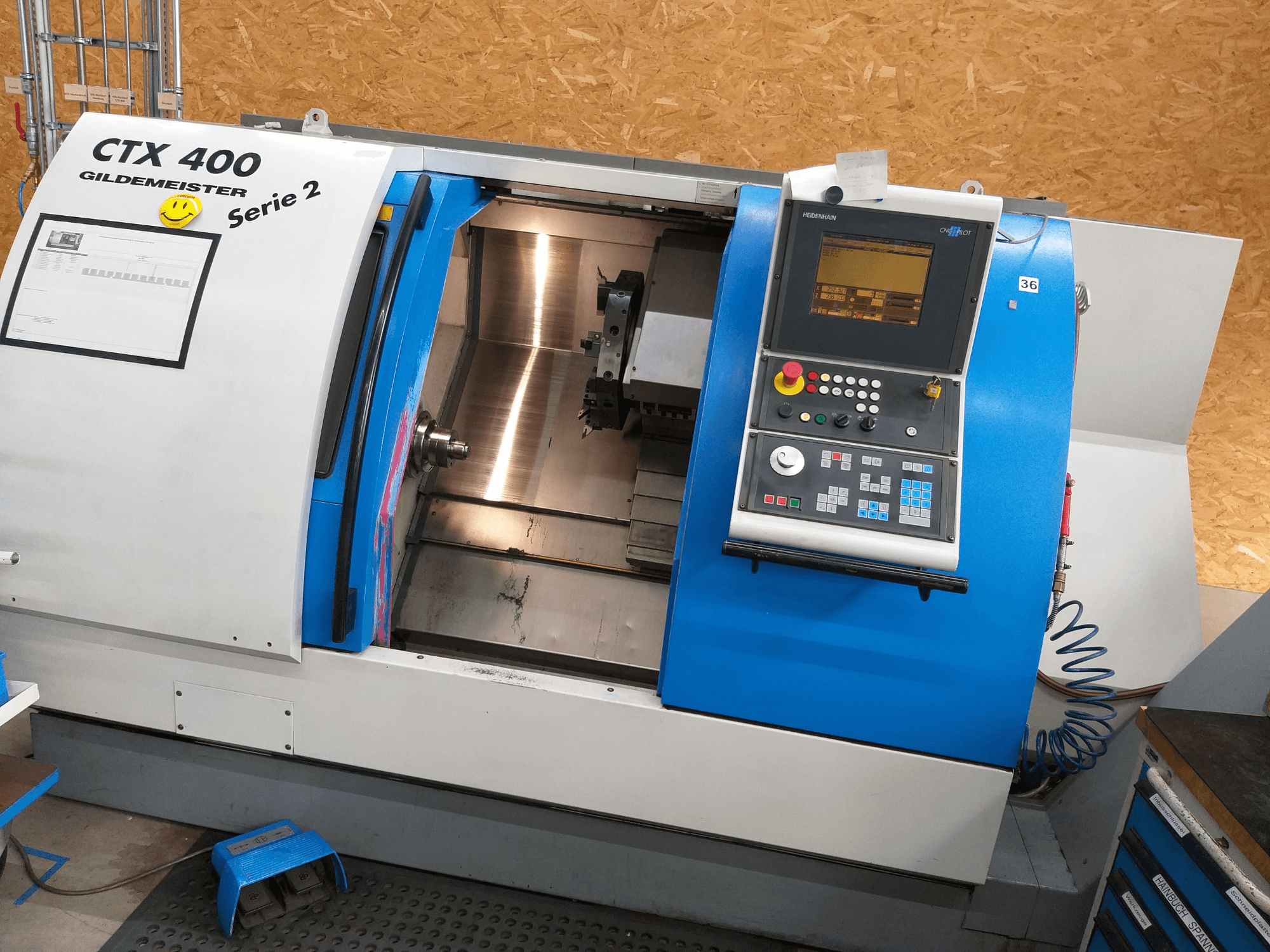 Torno horizontal Gildemeister CTX 400 Série 2, vista frontal que mostra o painel de controlo e o interior aberto da máquina.