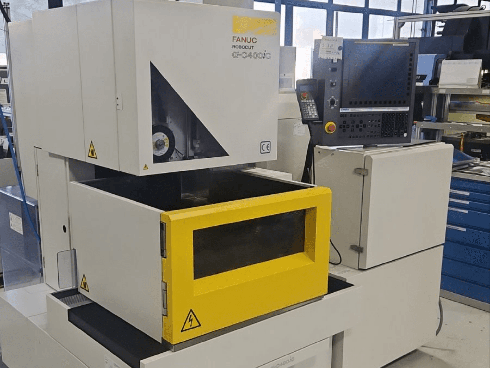 Máquina de eletroerosão por penetração FANUC Robocut alpha-C400iC, vista de frente, com câmara de peças de trabalho e painel de controlo amarelos.