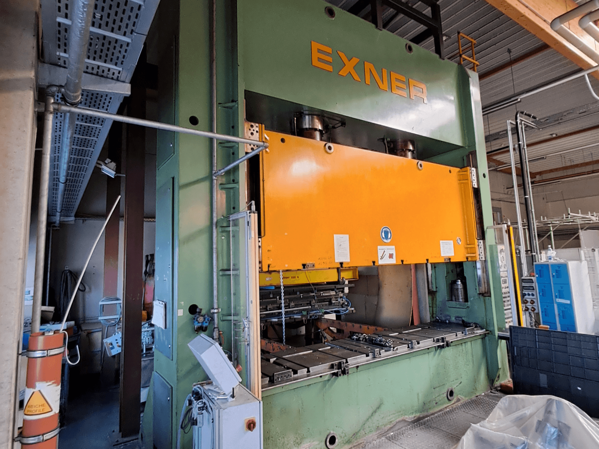 Prensa hidráulica EXNER EX SBR 200 vista de lado, com uma placa de prensagem laranja e um painel de controlo visível.