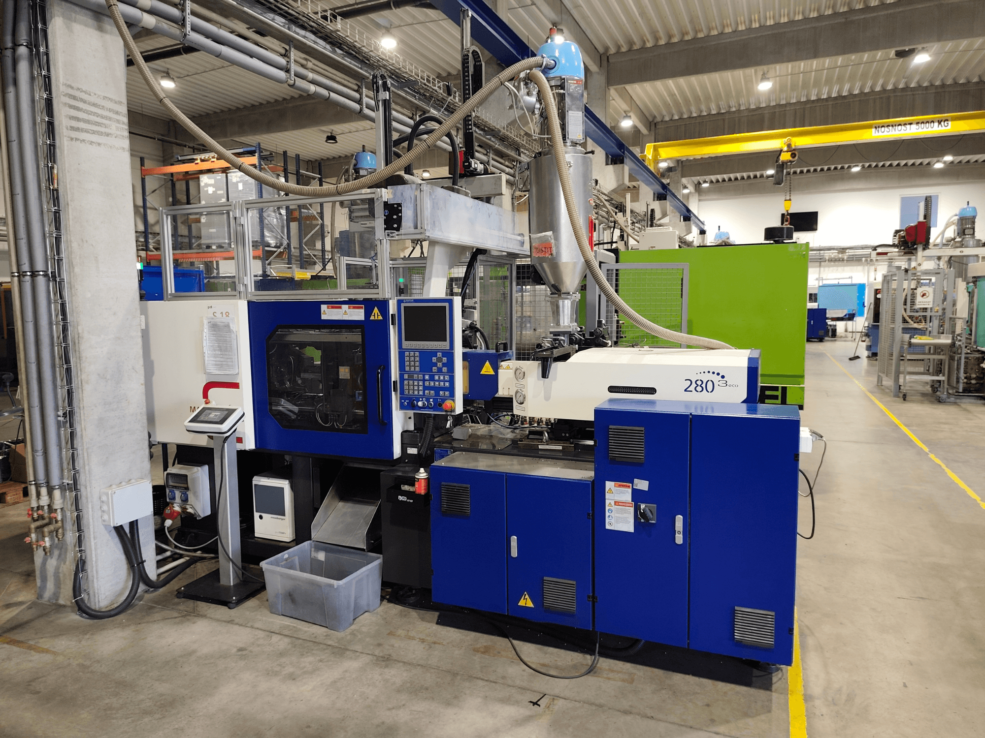 Máquina de moldagem por injeção hidráulica HAITIAN Mars III MA 900/280 A ECO, vista lateral, mostrando os comandos e a unidade de alimentação.