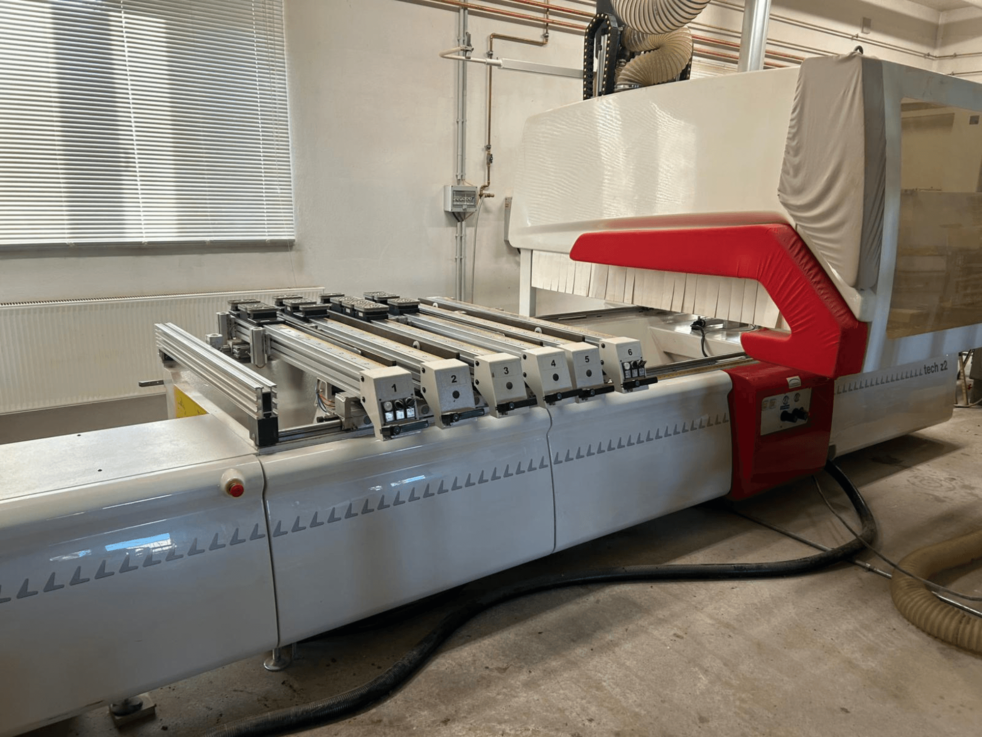 SCM TECH Z2-27-C mandriladora para madeira, vista lateral, mostrando o painel de controlo e os carris, com elementos de design em vermelho e branco.