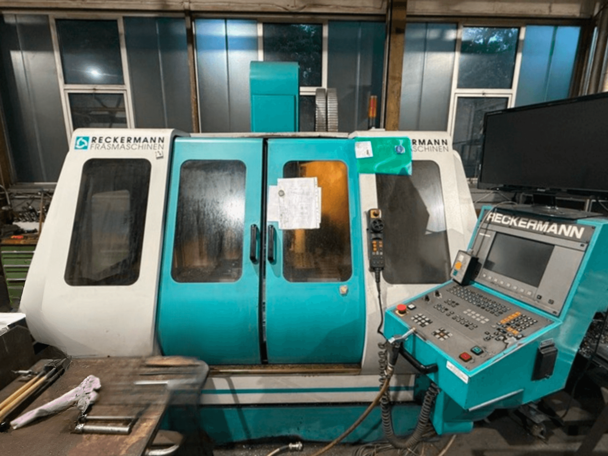 Centro de maquinação universal RECKERMANN VMC 850, vista frontal com painel de controlo e portas de vidro.