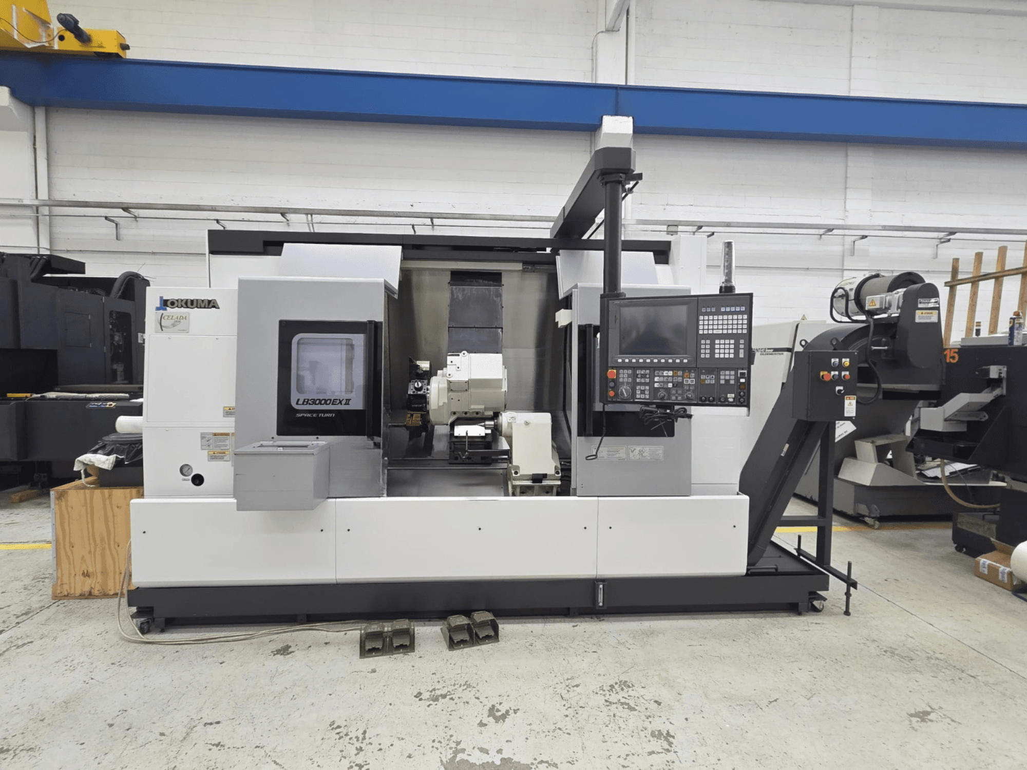 Okuma LB 3000 EXII máquina de torneamento horizontal vista de frente, com um painel de controlo e suporte de ferramentas.
