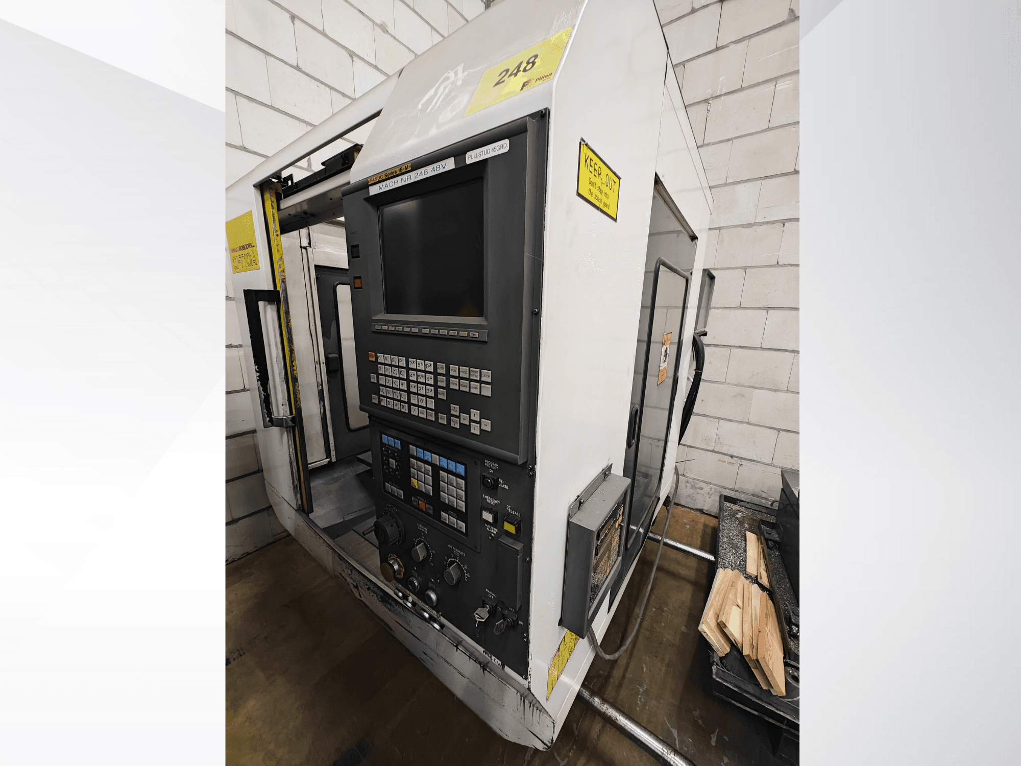 Máquina CNC modelo Nr 248, vista frontal, com painel de controlo com botões e visor, com peças de madeira numa prateleira próxima.